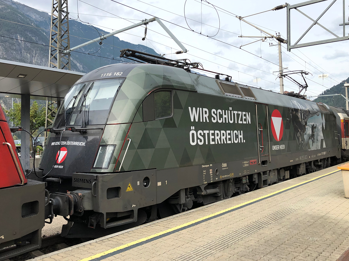 Die andere Seite der ÖBB 1116 182-7  Bundesheer  mit dem EC 164  Transalpin  von Graz Hbf nach Zürich HB beim Zwischenhalt in Landeck-Zams. Aufgenommen am 27.09.2021