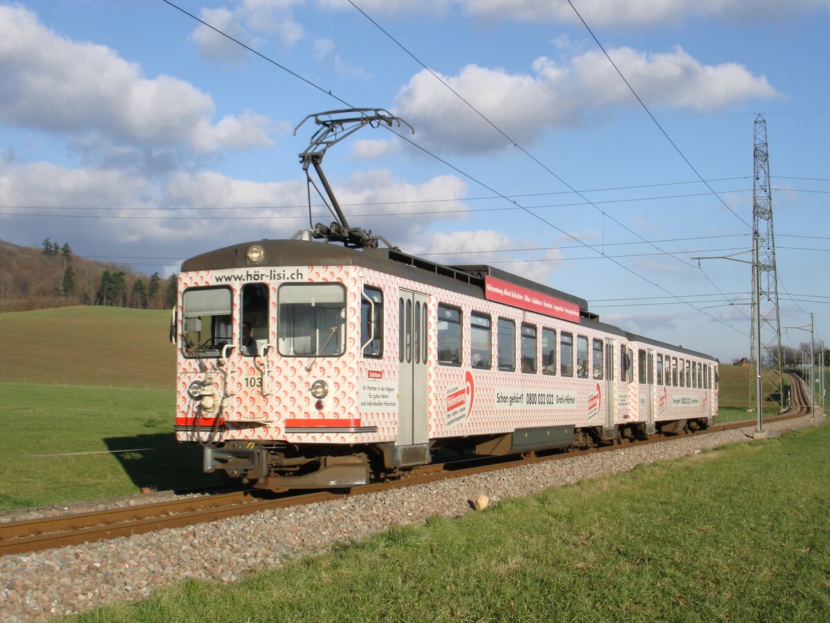 Die ASm-Be 4/4 103 und Bt 153 mit Werbung  Hör-Lisi  am 27. November 2007 als Regionalzug zwischen Wiedlisbach und Attiswil. Die beiden Fahrzeuge waren 1965 bei der SZB als Be 4/4 25 und Bt 86 in Betrieb genommen worden, wurden 1974/75 an die BTI verkauft (dort Be 4/4 2, Bt 23) und wurden 1997/98 zum RVO verschoben. Während der Steuerwagen 2012 verschrottet wurde, ist der Triebwagen heute noch als Reservetriebwagen vorhanden.