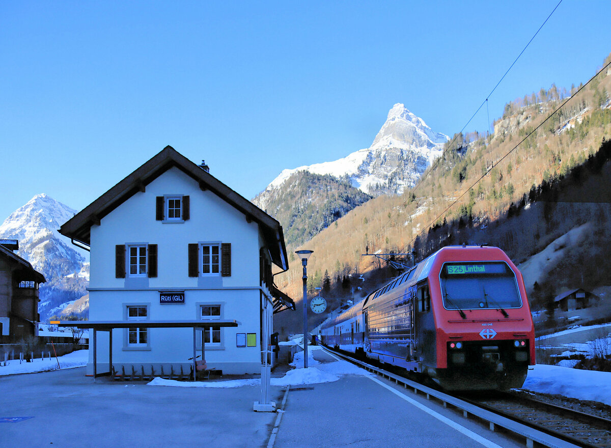 Die Bahn im Kanton Glarus: In Rüti (Glarus) ist es zwar schon nach 9 Uhr, aber noch herrscht eisige Kälte. Ein S-Bahn-Zug aus Zürich, gestossen von Re 450 046, ist soeben angekommen. 28.Februar 2022 
