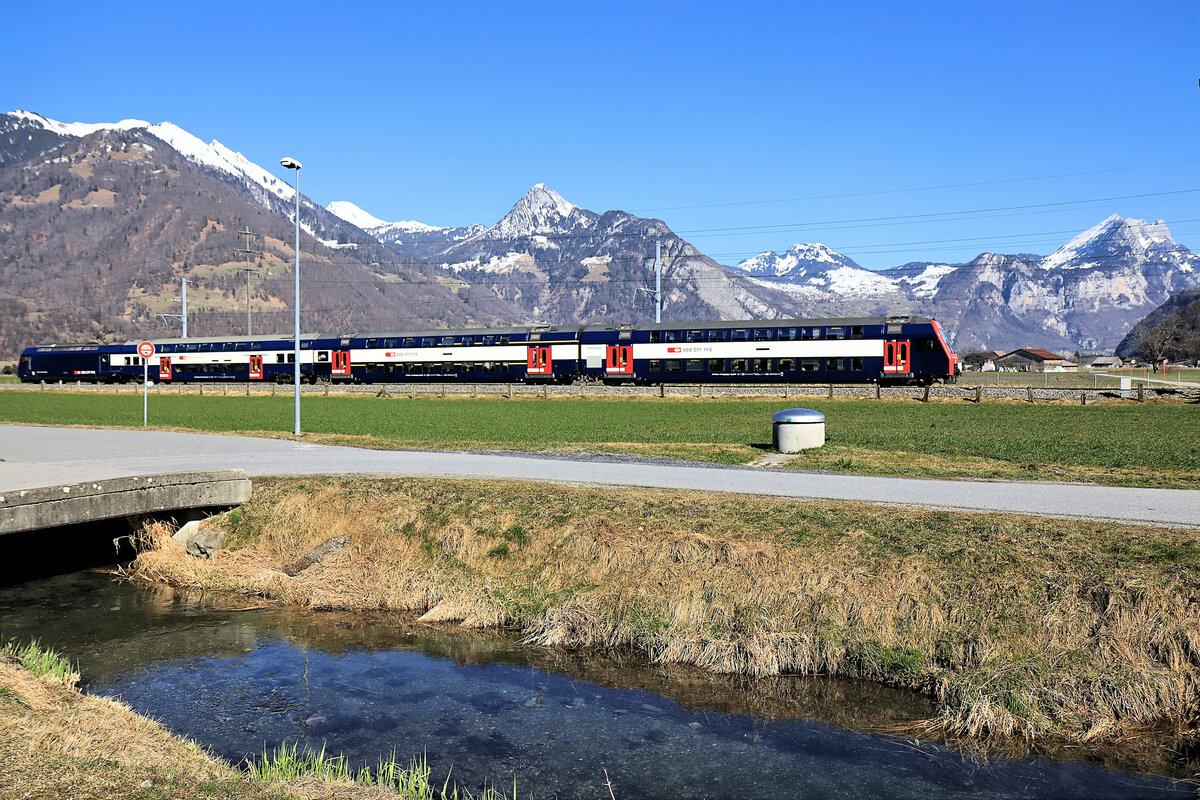 Die Bahn im Kanton Glarus: Niederurnen-Oberurnen, bereits in der Linth-Ebene, aber noch im Glarner Land. S-Bahnzug aus Zürich, geführt vom Doppelstock-Steuerwagen Bt 86-33 042(hinten Lok 450 006). 28.Februar 2022 