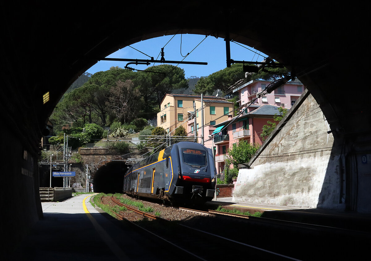 Die Bahnsteige der Bahnhöfe in der Cinque Terre befinden sich teilweise im Tunnel. Dieser Regionalzug von Levanto nach La Spezia befährt sogleich den Tunnel im Bahnhof Monterosso. Gut zu erkennen die gelbe Linie auf dem Bahnsteig beim linken Gleis, bei langen Züge findet der Fahrgastwechsel also teilweise im Tunnel statt. Monterosso, 26.4.2023
