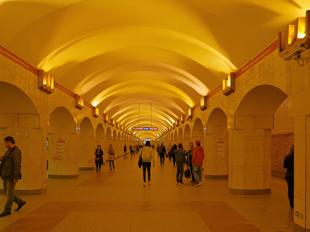 Die Bahnsteighalle der Station  Ploschtschad Alexandra Newskowo-2  der Metro der Linie 4 in St. Petersburg, 16.09.2017 

Im Gegensatz zur Linie 3 ist die Linie 4 mit stark orangefarbenem Licht ausgeleuchtet.