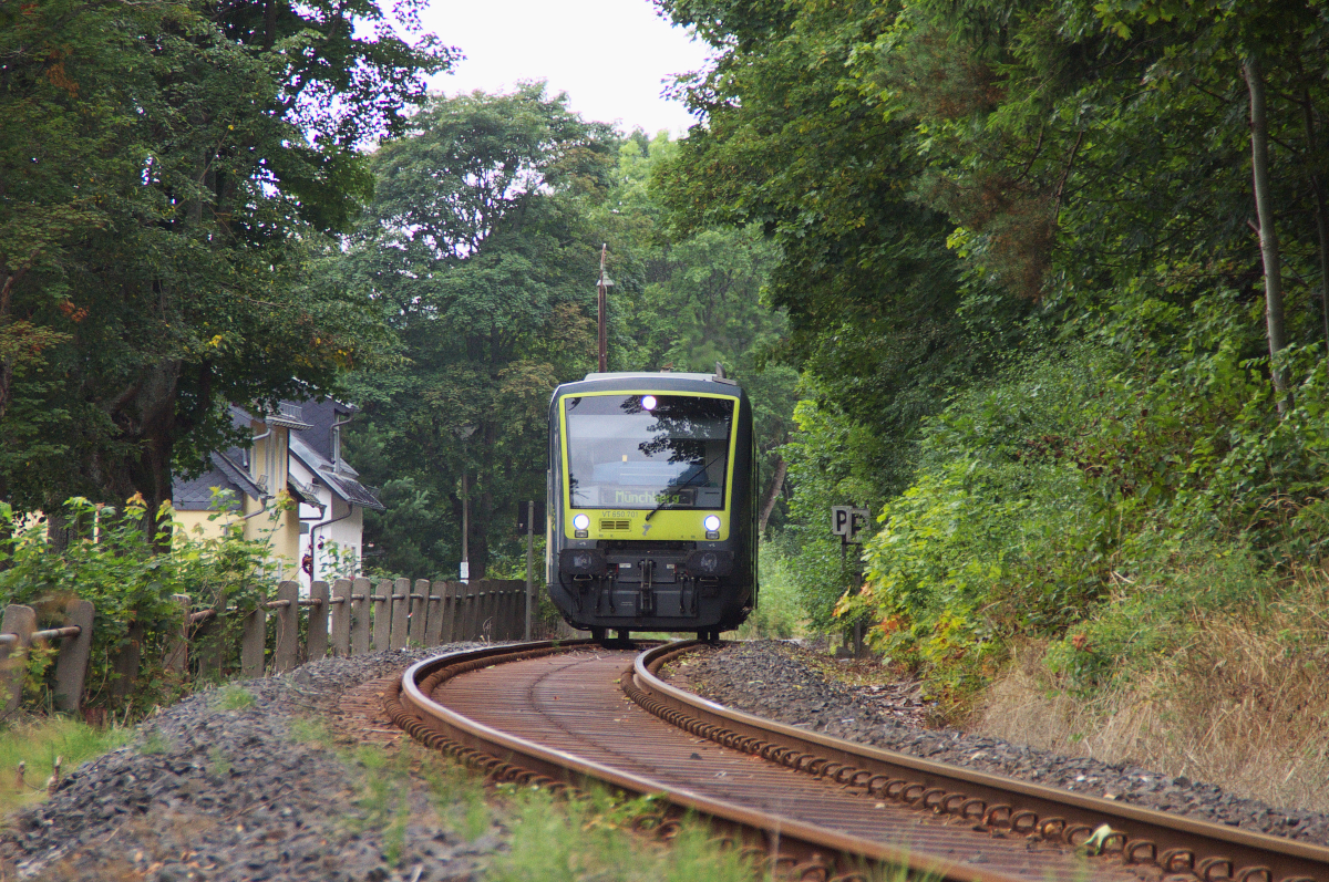 Die Bahnstrecke Hof - Bad Steben ist 27 Km lang und führt durch die oberfränkische eher dünn besiedelte Landschaft. Auf den ersten 11 Kilometern geht es steil bergauf, zwischen Hof (495 Meter) und Stegenwaldhaus (591 Meter) werden auch die modernen Fahrzeuge gefordert. Wir trafen am Ortsausgang von Bad Steben einen pensionierten Eisenbahner, der uns im Alter von über 80 Jahren von der guten alten Eisenbahnzeit erzählte. Es habe sogar früher Kurswagen aus dem Ruhrgebiet nach Bad Steben gegeben. Und er hat nicht gemogelt, wie man aus dem Kursbuch von 1985 ersehen kann. ( D 2656 Hof-Bamberg-Würzburg-Lauda-Heidelberg-Ludwigshafen mit Kurswagen Bad Steben/Hof-Dortmund, Bad Steben/Hof-Emden/Oldenburg) Wir begnügten uns mit VT 650.701 von Agilis der auf der Relation Bad Steben - Münchberg gerade Bad Steben verlassen hatte. Bahnstrecke 5021 Hof - Bad Steben 19.08.2015