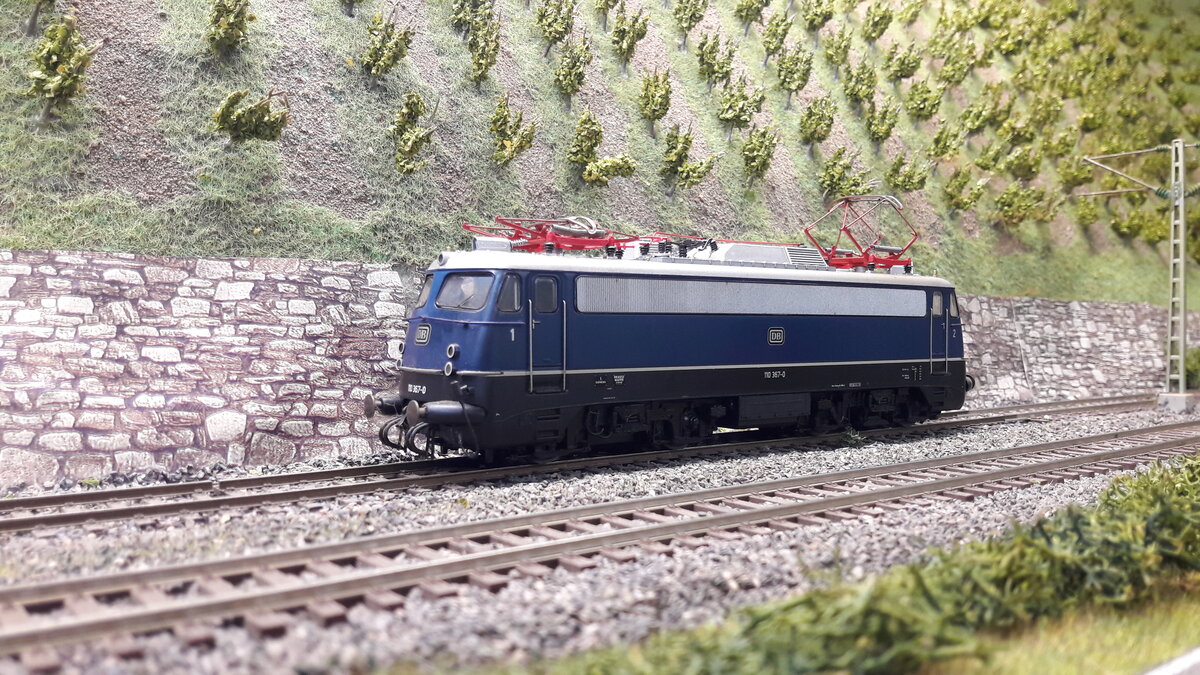 Die Baureihe E10,  5 Vorserienmaschinen ( dazu gab es schon Bilder und Erklärungen) . Die ersten Serienlokomotiven waren die E10 Kasten ab 1956.  Die Baureihenbezeichnungen durchliefen die Ordnungsnummern (ab 1968 )   110 / 112 / 113 / 114 / 115 .  Da die Lok als Einheitslokomotive entwickelt wurde, gab es in der Kastenvariante  noch die E40 (140) , E41 (141) und die E50 (150 ).  Die ersten Kasten E10  waren die E10.1 , spätere Ausführungen der Kasten E10  bekamen die Doppellampen vorne , das waren die E10.2 .  Ab Maschine 288 wurde dann die Bügelfaltenform eingeführt, welche zuvor schon an den Rheingoldmaschinen realisiert wurde. Diese wurden als E10.3 bezeichnet , die Rheingoldmaschinen liefen unter E10.12. Es gab unglaublich viele Varianten , mit Regenrinne und ohne, verschiedenste Lamellenausführungen, usw. usw .  Auch etliche Farbvarianten hat die Lok durchgemacht
Hier nun das Modell der Ursprungsvariante Bügelfalten E10 , silberne Regenrinne, durchgehendes Doppeldüsenlüftergitter, verkleidete Pufferbohlen, Griffumlauf vorne.
Modell 110 367-0  Roco 43790 DC digital
