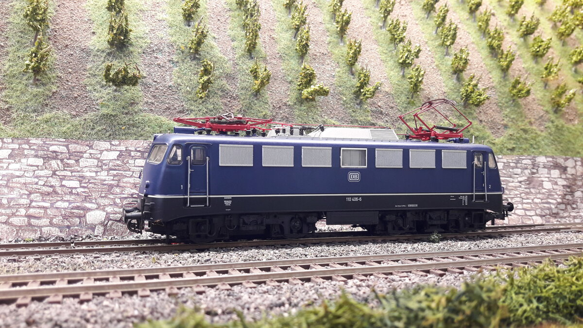 Die Baureihe E10,  5 Vorserienmaschinen ( dazu gab es schon Bilder und Erklärungen) . Die ersten Serienlokomotiven waren die E10 Kasten ab 1956.  Die Baureihenbezeichnungen durchliefen die Ordnungsnummern (ab 1968 )   110 / 112 / 113 / 114 / 115 .  Da die Lok als Einheitslokomotive entwickelt wurde, gab es in der Kastenvariante  noch die E40 (140) , E41 (141) und die E50 (150 ).  Die ersten Kasten E10  waren die E10.1 , spätere Ausführungen der Kasten E10  bekamen die Doppellampen vorne , das waren die E10.2 .  Ab Maschine 288 wurde dann die Bügelfaltenform eingeführt, welche zuvor schon an den Rheingoldmaschinen realisiert wurde. Diese wurden als E10.3 bezeichnet , die Rheingoldmaschinen liefen unter E10.12. Es gab unglaublich viele Varianten , mit Regenrinne und ohne, verschiedenste Lamellenausführungen, usw. usw .  Auch etliche Farbvarianten hat die Lok durchgemacht
Hier das Modell der  Bügelfalten E10  schon weiter fortgeschritten , keine Regenrinne, einzelne Klattelüfter, viereckiges Maschinenraumfenster, nicht geteilt, keine verkleideten Pufferbohlen mehr, Griffumlauf vorne fehlt diesmal.
Modell 110 406-6  Roco 62496 DC digital