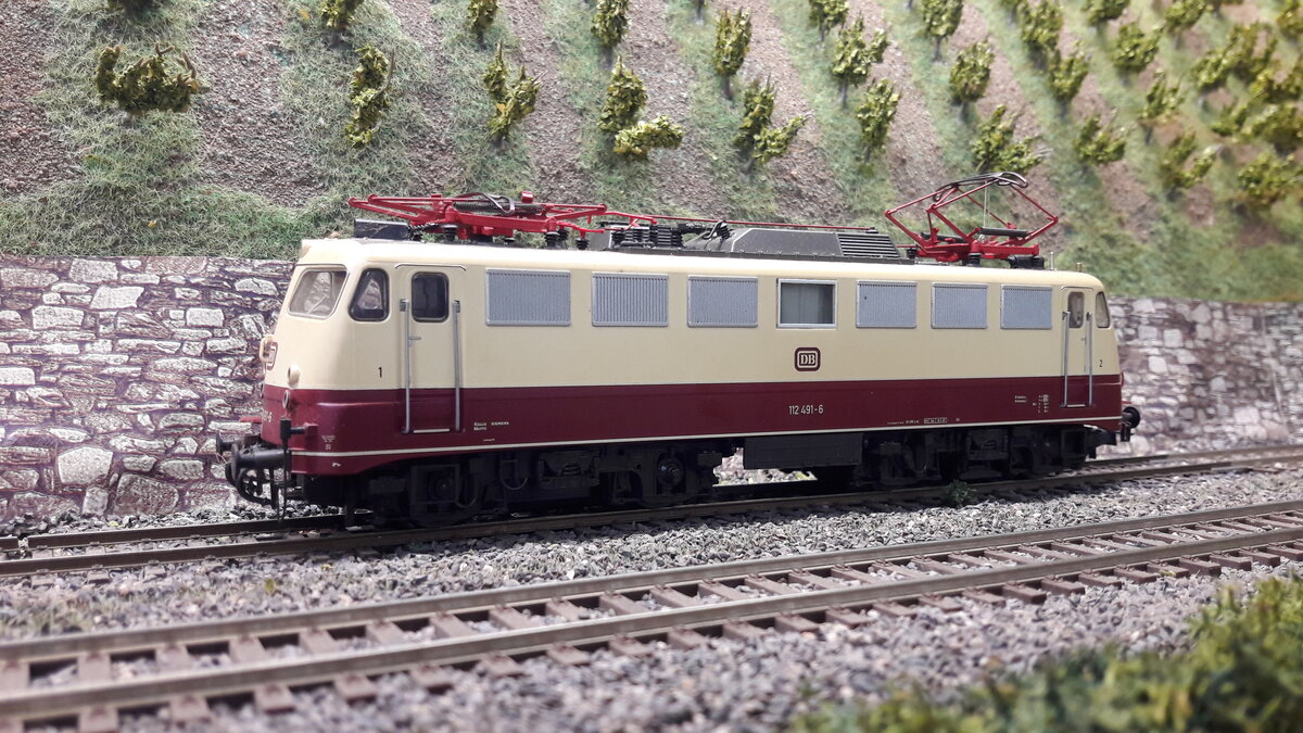 Die Baureihe E10, 5 Vorserienmaschinen ( dazu gab es schon Bilder und Erklärungen) . Die ersten Serienlokomotiven waren die E10 Kasten ab 1956. Die Baureihenbezeichnungen durchliefen die Ordnungsnummern (ab 1968 ) 110 / 112 / 113 / 114 / 115 . Da die Lok als Einheitslokomotive entwickelt wurde, gab es in der Kastenvariante noch die E40 (140) , E41 (141) und die E50 (150 ). Die ersten Kasten E10 waren die E10.1 , spätere Ausführungen der Kasten E10 bekamen die Doppellampen vorne , das waren die E10.2 . Ab Maschine 288 wurde dann die Bügelfaltenform eingeführt, welche zuvor schon an den Rheingoldmaschinen realisiert wurde. Diese wurden als E10.3 bezeichnet , die Rheingoldmaschinen liefen unter E10.12. Es gab unglaublich viele Varianten , mit Regenrinne und ohne, verschiedenste Lamellenausführungen, usw. usw . Auch etliche Farbvarianten hat die Lok durchgemacht Hier das Modell der Bügelfalten E10/112 ... 112 491-6 in TEE Farben, keine Regenrinne, einzelne Klattelüfter , Maschinenraumfenster viereckig nicht geteilt, keine verkleideten Pufferbohlen , kein Griffumlauf vorne . Modell Roco 62548 DC digital