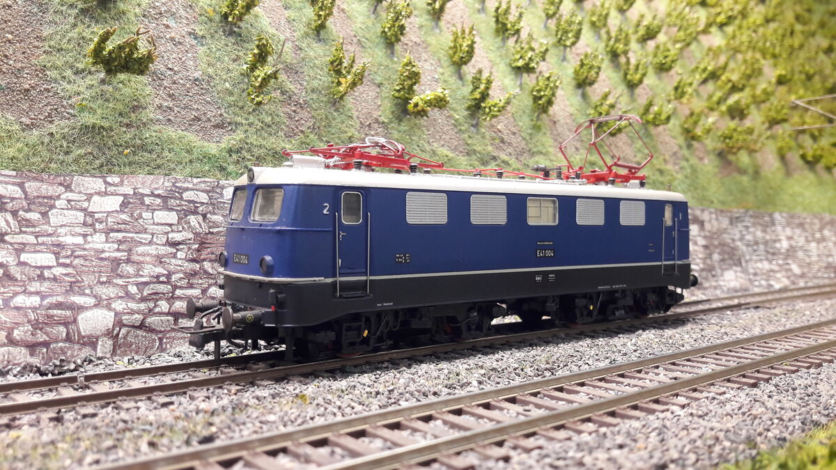 Die Baureihe E10/E40/E41, 5 Vorserienmaschinen ( dazu gab es schon Bilder und Erklärungen) . Die ersten Serienlokomotiven waren die E10 Kasten ab 1956. Die Baureihenbezeichnungen durchliefen die Ordnungsnummern (ab 1968 ) 110 / 112 / 113 / 114 / 115 . Da die Lok als Einheitslokomotive entwickelt wurde, gab es in der Kastenvariante noch die E40 (140), (139) , E41 (141) und die E50 (150 ). Die ersten Kasten E10 waren die E10.1 , spätere Ausführungen der Kasten E10 bekamen die Doppellampen vorne , das waren die E10.2 . Ab Maschine 288 wurde dann die Bügelfaltenform eingeführt, welche zuvor schon an den Rheingoldmaschinen realisiert wurde. Diese wurden als E10.3 bezeichnet , die Rheingoldmaschinen liefen unter E10.12. Es gab unglaublich viele Varianten , mit Regenrinne und ohne, verschiedenste Lamellenausführungen, usw. usw . Auch etliche Farbvarianten hat die Lok durchgemacht. Die BR E41 / 141 war grundsätzlich kürzer wie E10 und E40 . Hier das Modell der ersten Serien E41, E41 004,  noch in blau , tatsächlich noch mit Fenstern , unterschiedlich je Seite. E41 004 rechte Seite 1 Fenster, Regenrinne, Schweigerlamellenlüfter, Griffumlauf vorne , Einfachlampen, geteiltes abgerundetes Maschinenraumfenster . Modell Roco 43636 DC nachdigitalisiert