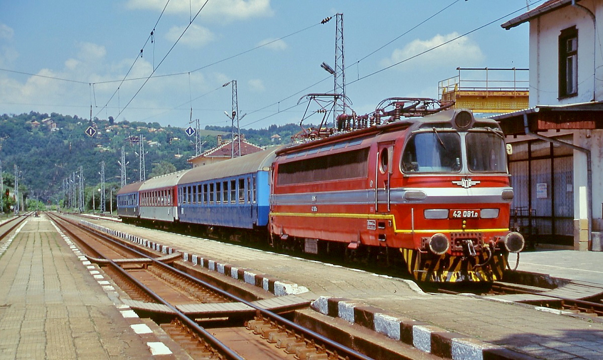 Die BDZ 42 015.0 ist im Juni 2003 auf der durch das Balkangebirge führenden Strecke von Gorna Orjahovitza nach Stara Zagora in Trjawna angekommen. Die BDZ-Reihe 42 ist baugleich mit den Lokomotiven der Reihe 230 der CD, allerdings war schon damals die charakteristische Front aus glasfaserverstärktem Poyester bei den meisten Lokomotiven ersetzt. Skoda lieferte zwischen 1965 und 1970 90 Lokomotiven an die BDZ.