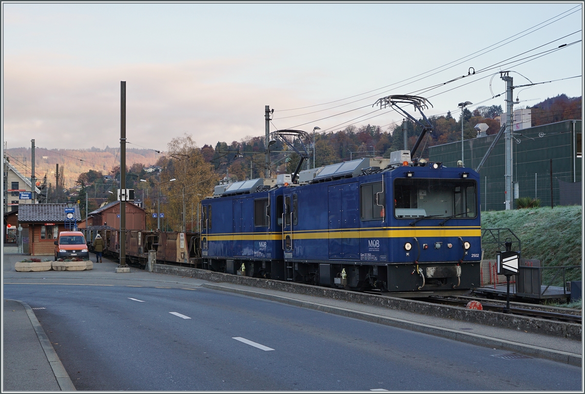 Die beiden MOB Gem 2/2 2502 und 2504 warten mit einem leeren Schotterwagenzug in Blonay auf die Abfahrt nach Chamby. 

9. November 2021