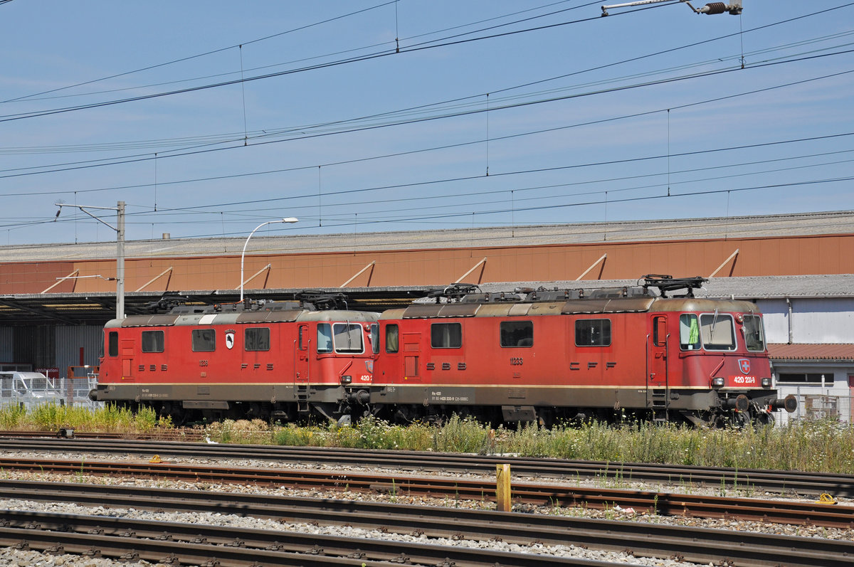 Die beiden Re 4/4 II 11233 und 11239 stehen auf einem Abstellgleis beim Bahnhof Pratteln. Die Aufnahme stammt vom 16.07.2018.