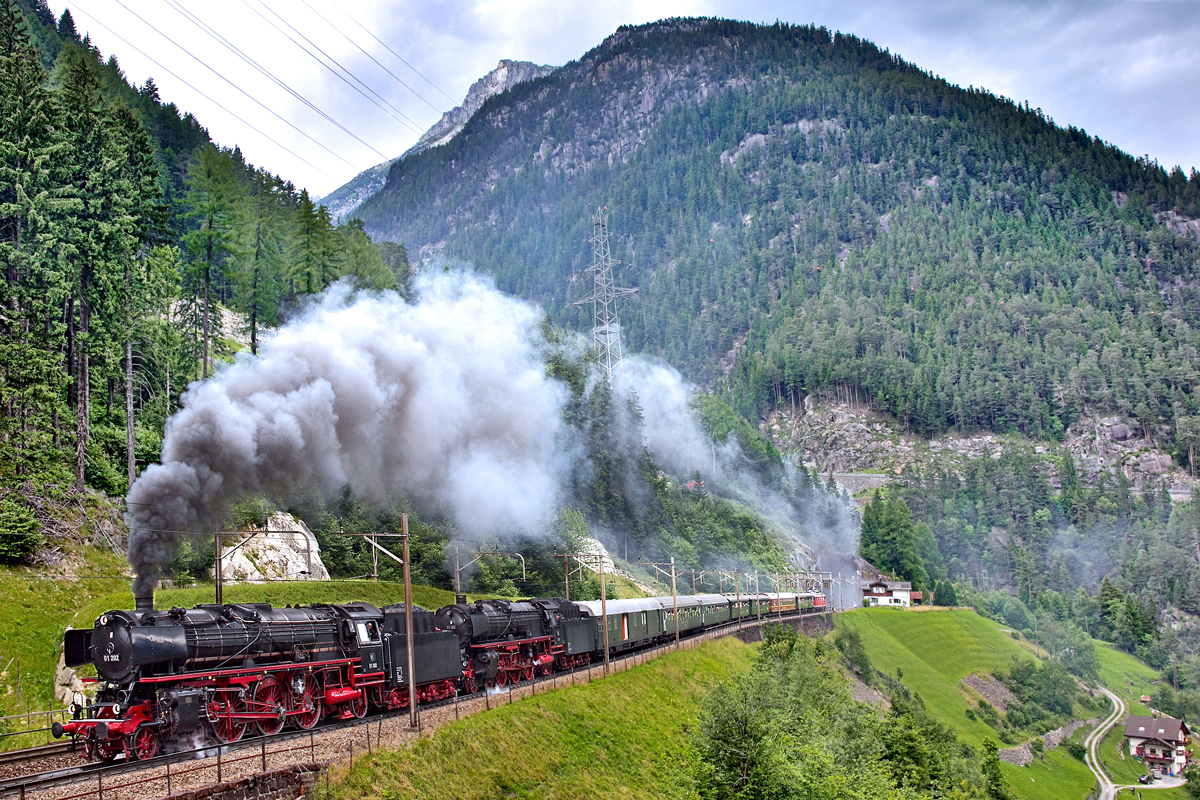 Die beiden Schnellzugsdampflokomotiven 01 202 und die 01 150 dampfen in Doppeltraktion mit ihrem Sonderzug bei minütlich wechselndem Wetter von Sonne,Wolken und Regen der Sonnenstube der Schweiz entgegen.Bild Wassen/ 3.Ebene den 27.6.2015