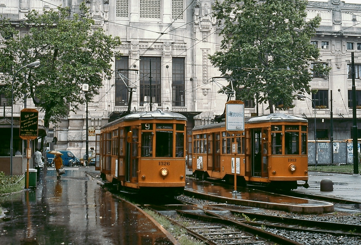 Die beiden Triebwagen 1526 und 1913 stehen an einem völlig verregneten Maitag 1996 abfahrbereit vor dem Empfangsgebäude von Milano Centrale