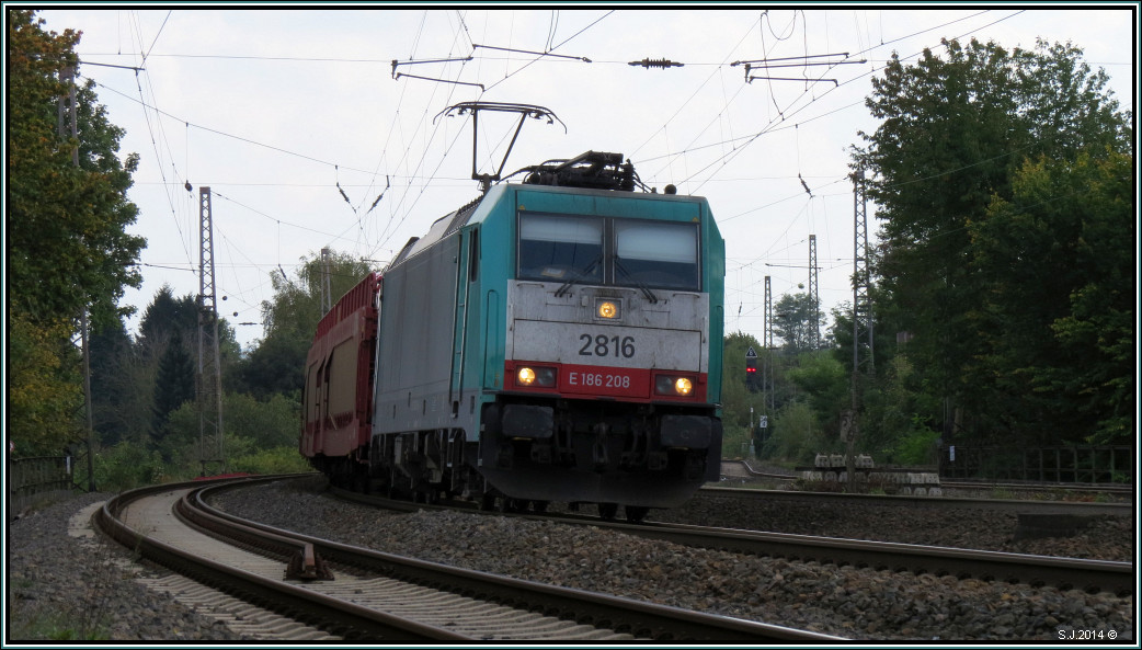Die belgische Cobra 2816 im Gleisbogen bei Eschweiler auf der Kbs 480 unterwegs nach Aachen West am 01.Oktober 2014. Am Haken ein Autotransportzug aus Polen.Szenario vom P&R Platz aus festgehalten.