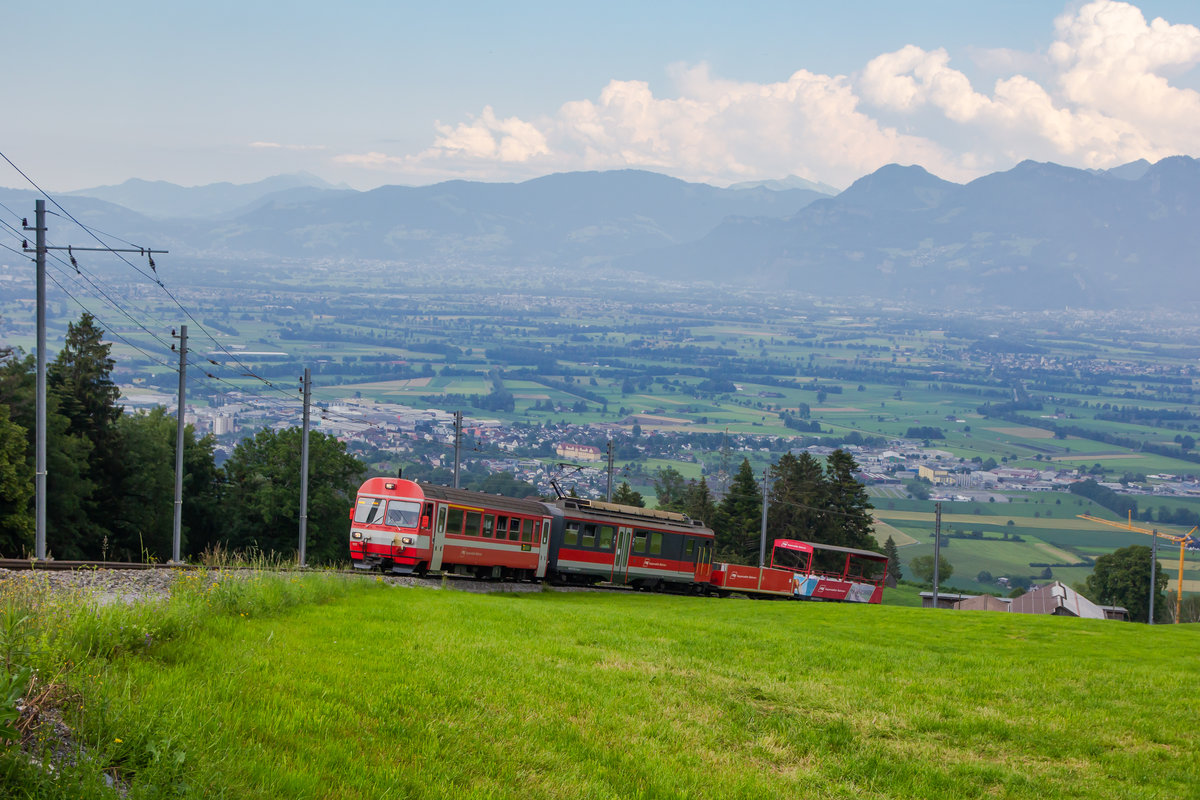 Die Bergkulisse des Rheintal im Hintergrund. Erklimtm der Triebwagen aus Altstätten gen Gais den Berg kurz vor Kreuzstrasse. 27.6.20