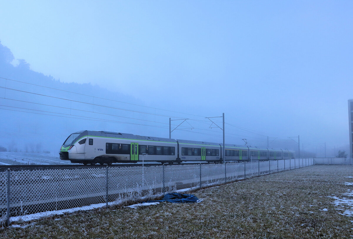 Die Berner S-Bahn: Während sich blauer Himmel über dem Nebel erahnen lässt, zieht ein BLS Flirt MIKA als S4 vorüber, Richtung Bern, Burgdorf, Ramsei und Langnau im Emmental. Wabern, 16.Januar 2022 
