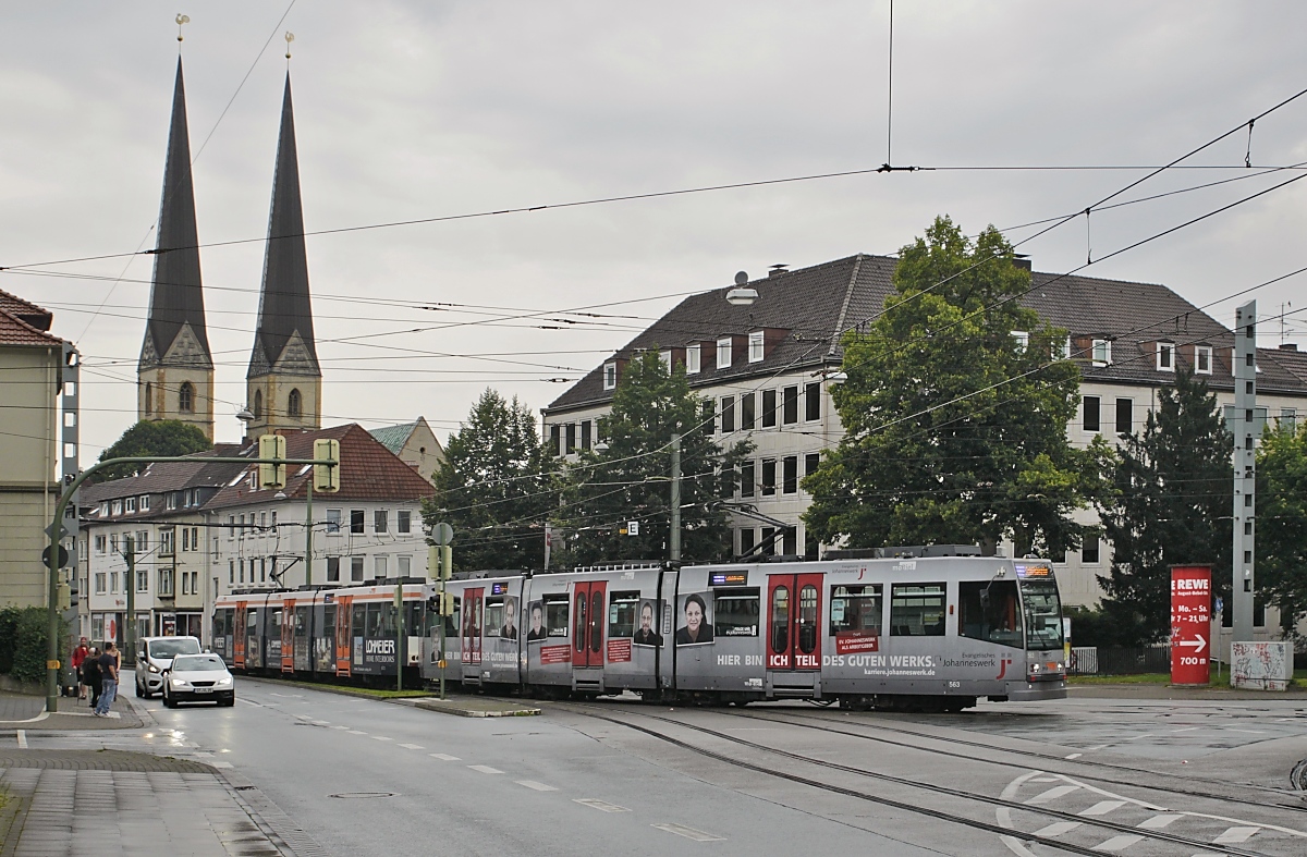 Die Bielefelder Stadtbahnwagen 563 und 572 biegen am 01.08.2020 von der Kreuzstraße in den Niederwall ein, im Hintergrund die Neustädter Marienkirche