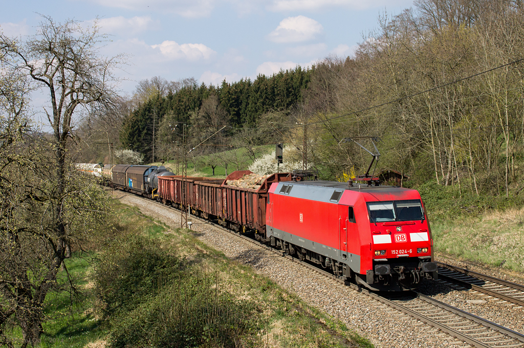 Die blitzsaubere 152 024-6 zieht am 28. März 2014 einen gemischten Güterzug über die Filsbahn in Richtung Ulm. Kurz vor Gingen entstand diese Aufnahme.