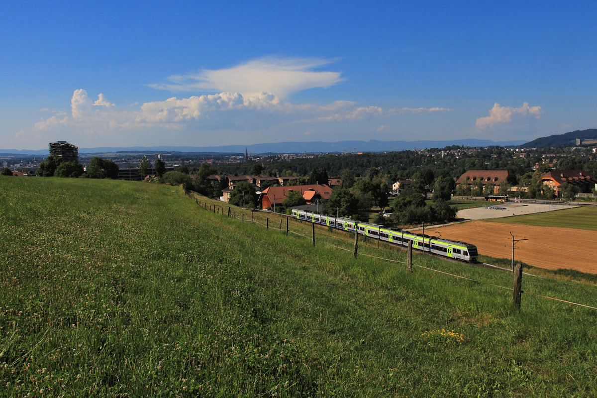 Die BLS in der grossen Hitze: Jetzt brauen sich über dem Jura im Hintergrund schon die ersten Gewitter zusammen, während zwei NINA Züge (der vordere im neuen, der hintere im alten Anstrich) von Bern nach Thun fahren. 26.Juli 2018 