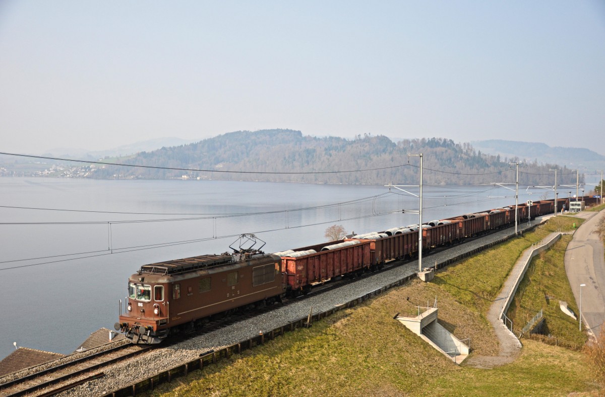 Die BLS Re 4/4 186 ist mit ihrem Güterzug bei der Haltestelle Walchwil-Hörndli entlang des Zugersees Richtung Gotthard unterwegs. Aufgenommen am 19.03.2015