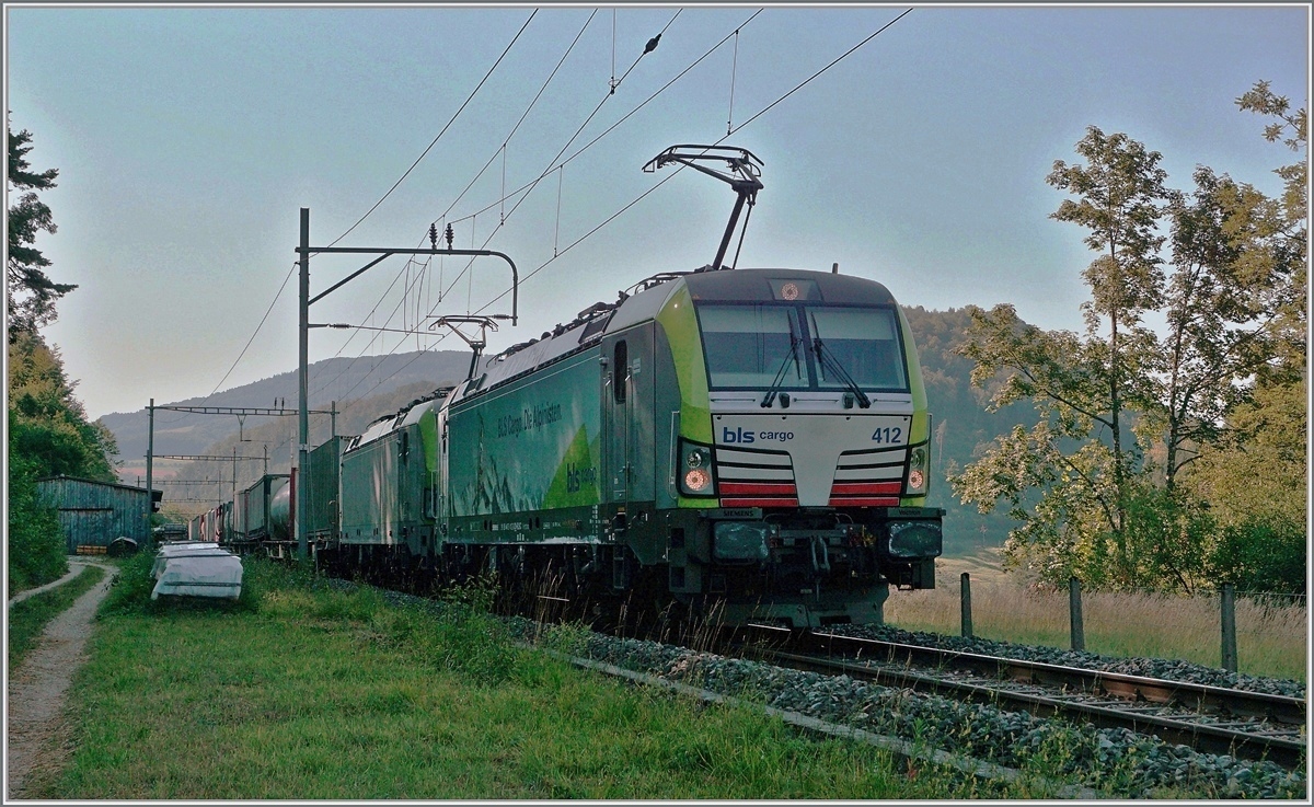 Die BLS Re 475 412 und eine weitere fahren im Schatten mit einem via Alte Hauensteinlinie umgeleiteten Güterzug Richtung Sissach. Der Zug fährt gerade durch den Bahnhof Sommerau und wird in Kürze eine Stelle erreichen die sich  Gotthard  nennt. 
18. Juli 2018