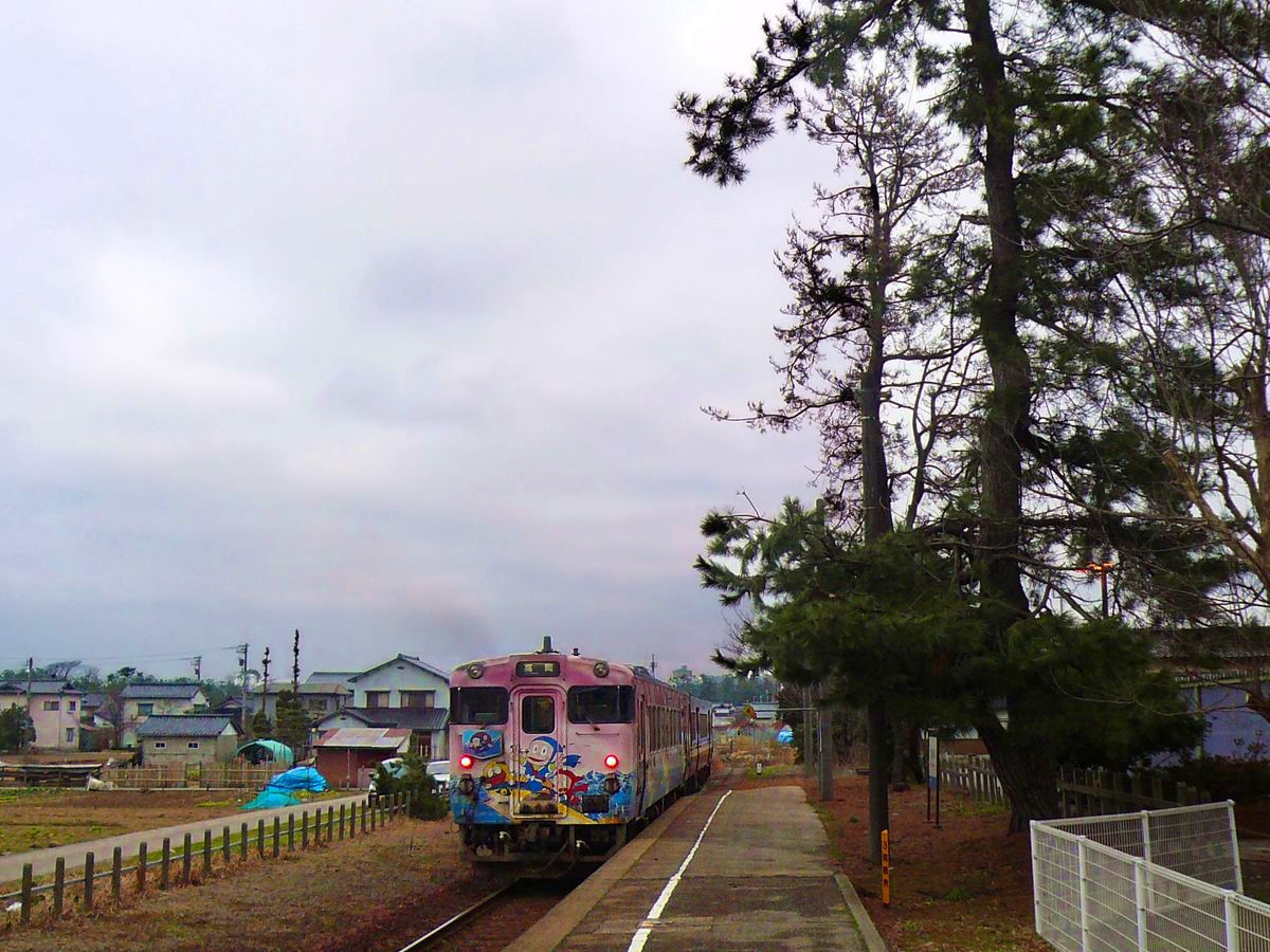 Die bunten Triebwagen der Region Takaoka: KIHA 40 2136 mit dem kleinen Ninja Hattori auf der Himi-Linie der Bucht von Takaoka entlang. Shimao, 28.Februar 2010.