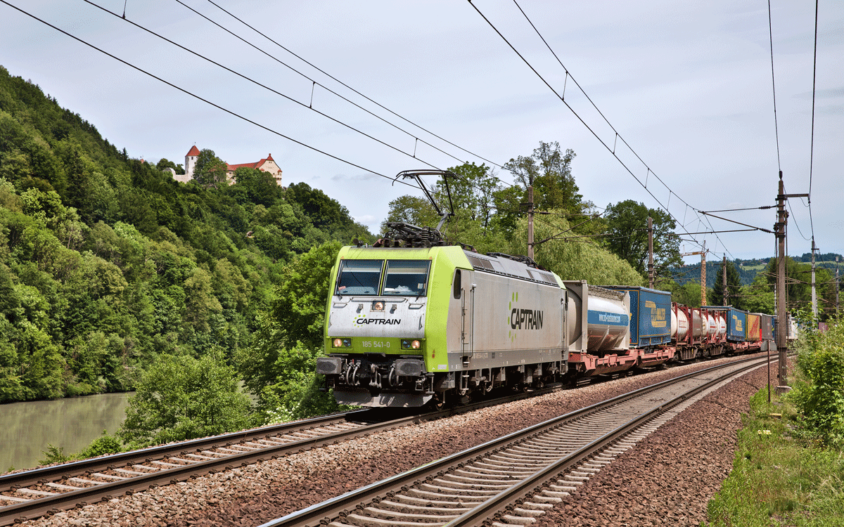 Die Captrain 185 541-0 fährt mit einem UKV Zug in Wernstein am Inn vorüber.Bild vom 8.6.2017