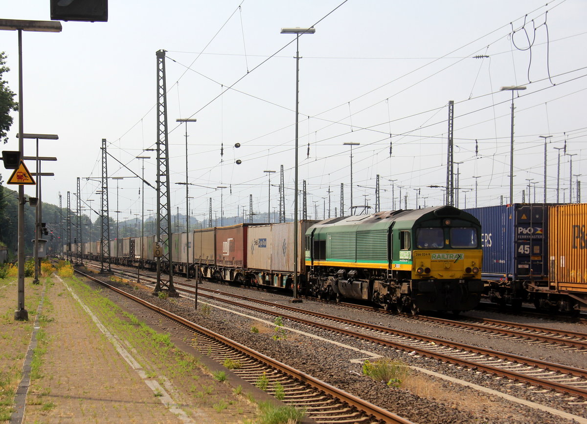 Die Class 66 266 024-9 von Railtraxx steht in Aachen-West mit einem langen Containerzug aus Köln-Eifeltor(D) nach Genk-Haven(B) und wartet auf die Abfahrt nach Belgien.
Aufgenommen vom Bahnsteig in Aachen-West. 
Bei Sommerwetter am Nachmittag vom 30.6.2019.