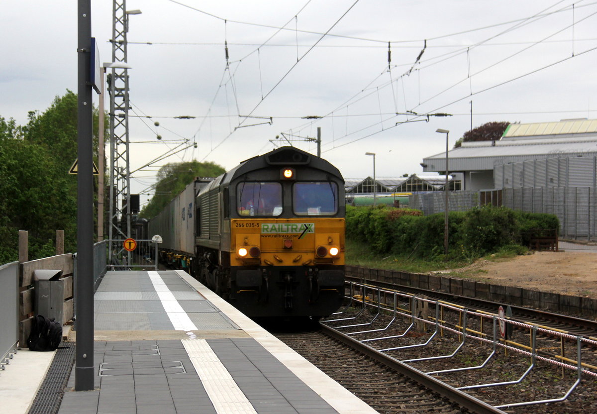 Die Class 66 266 035-5 von Railtraxx kommt als Umleiter mit einem Containerzug aus Köln-Eifeltor(D) nach Genk-Haven(B) und fährt durch Kohlscheid aus Richtung Herzogenrath und fährt die Kohlscheider-Rampe hoch nach Aachen-West. 
Aufgenommen von Bahnsteig 2 in Kohlscheid. 
Am 25.4.2019. 