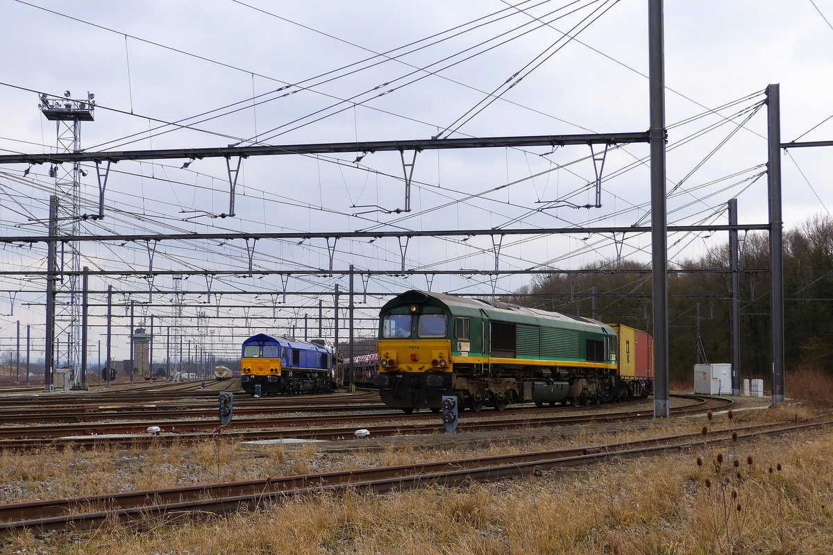 Die Class 66 653-03 von HSL steht in Montzen-Gare(B) mit einem langen Autozug.
Rechts daneben steht die Class 66 PB14 von Crossrail mit einem Güterzug. 
Aufgenommen in Montzen-Gare(B).
Bei Sonne und Schneewolken am Eiskalten Nachmittag vom 18.3.2018.
