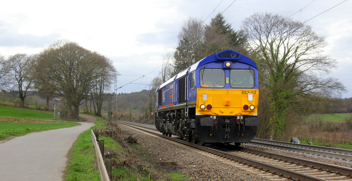 Die Class 66 653-03 von HSL-Belgium kommt als Lokzug aus Montzen(B) nach Aachen-West(D) und fährt die Gemmenicher-Rampe herunter nach Aachen-West. Aufgenommen an der Gemmenicher-Rampe am Gemmenicher-Weg auf dem Montzenroute. 
Bei Sonne und Regenwolken am Nachmittag vom 6.3.2019.
