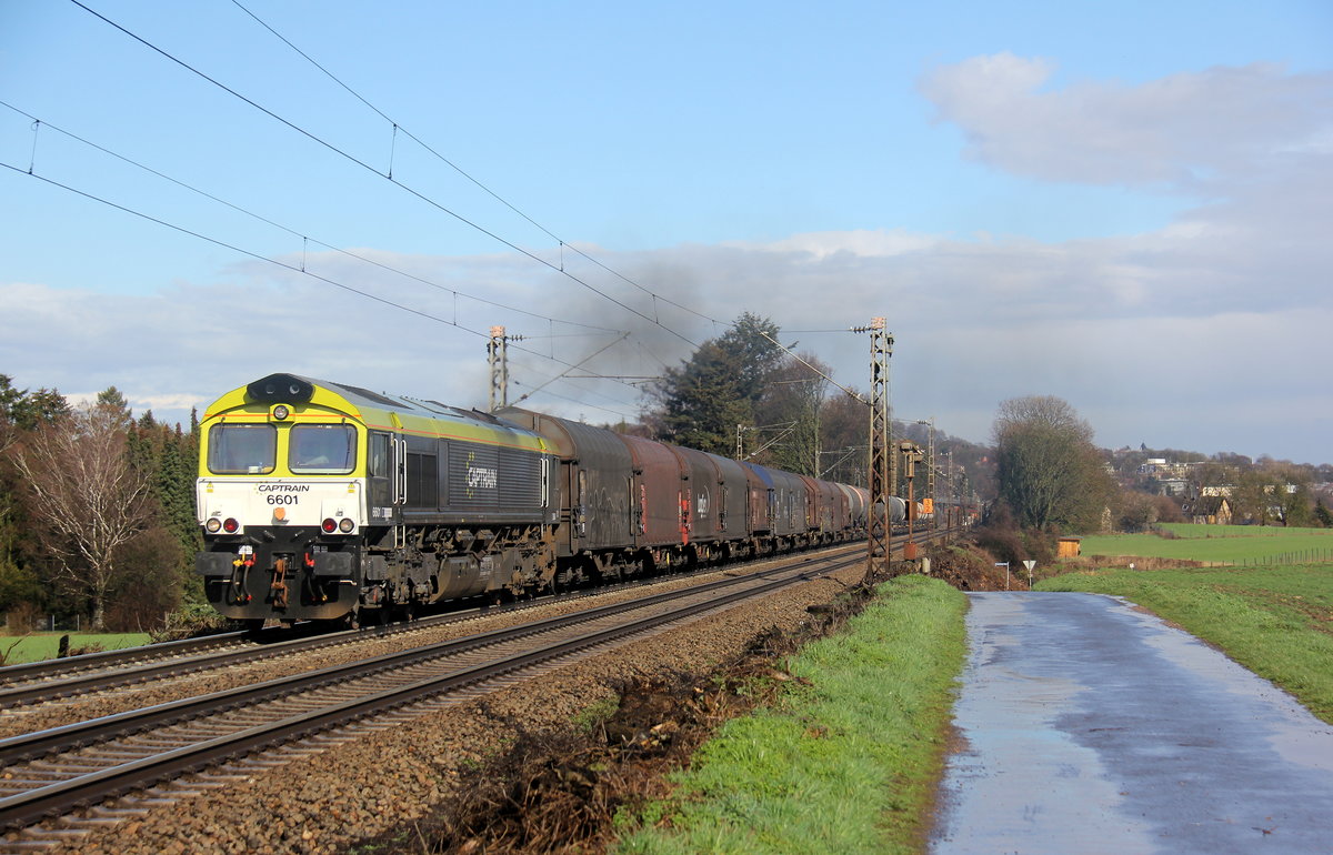 Die Class 66 6601 von Captrain fährt jetzt für Railtraxx kommt mit viel Dieselpower die Gemmenicher-Rampe hochgefahren aus Richtung Aachen-West mit einem schweren gemischten Güterzug aus Linz Voestalpine(A) nach Antwerpen Waaslandhaven(B) und am Ende fährt 185 510-5 von Railtraxx als Schubhilfe bis zum Gemmenicher-Tunnel. 
Aufgenommen an der Montzenroute am Gemmenicher-Weg. 
Bei Sonne und Regenwolken am Nachmittag vom 7.3.2019.
