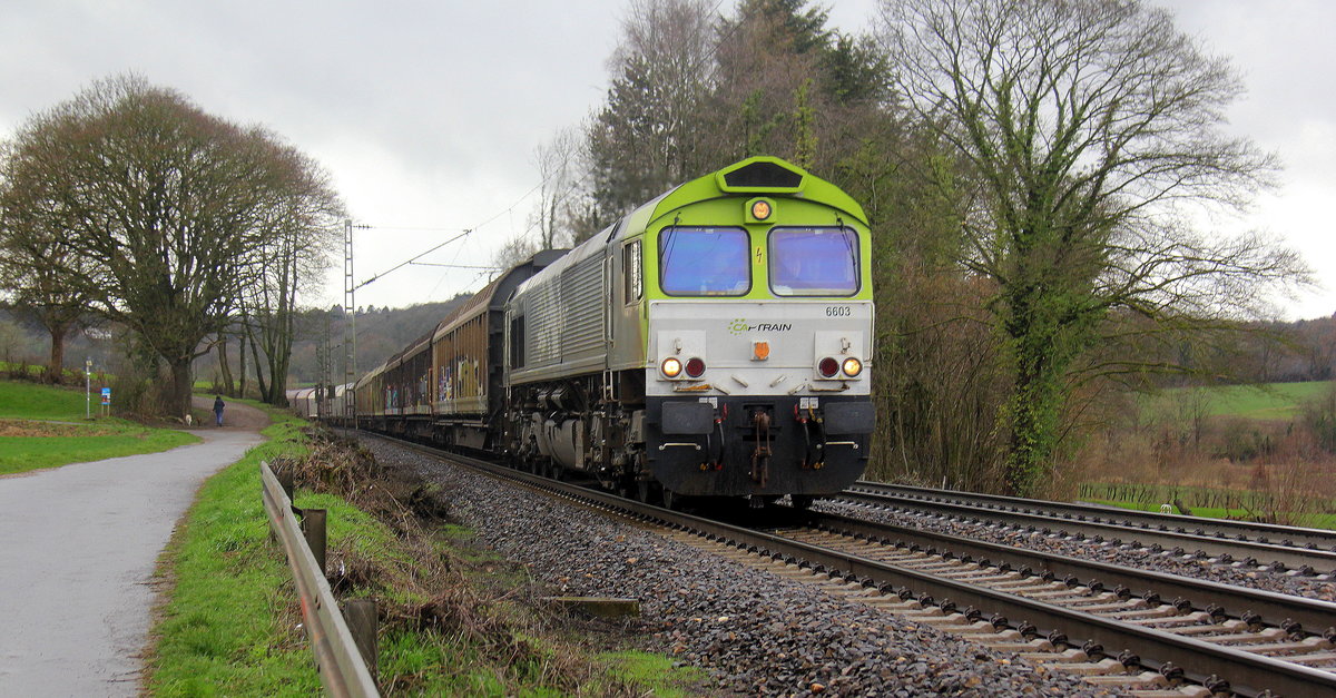 Die Class 66 6603 von Captrain fährt jetzt für Railtraxx kommt die Gemmenicher-Rampe herunter nach Aachen-West mit einem Güterzug aus Antwerpen-Waaslandhaven(B) nach Linz-Voestalpine(A). 
Aufgenommen an der Montzenroute am Gemmenicher-Weg.
Bei Sonne und Regenwolken am Mittag vom 5.3.2019. 