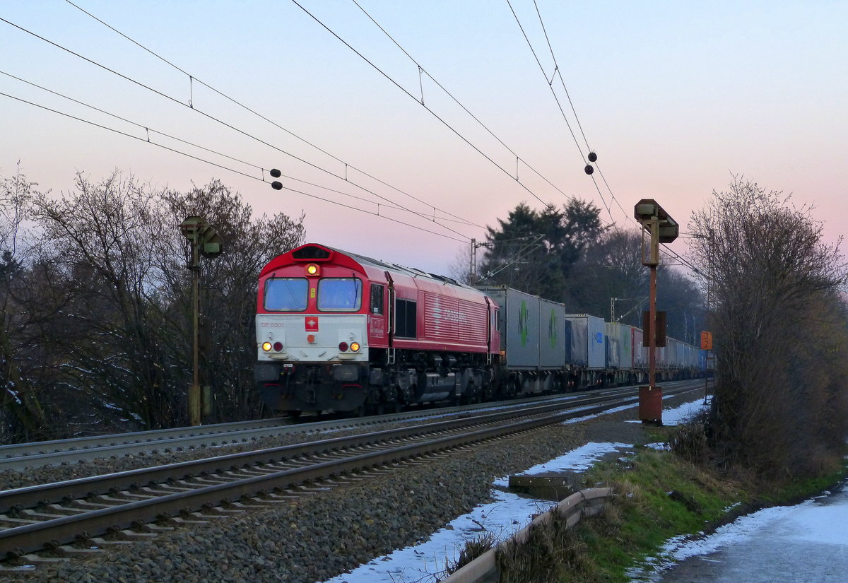 Die Class 66 DE6301  Debora  von Crossrail kommt mit viel Dieselpower    hochgefahren aus Richtung Aachen-West mit einem  Containerzug aus Köln-Eifeltor(D) nach Genk-Haven(B)  und fährt in Richtung Gemmenicher-Tunnel,Botzelaer(B),Gemmenich(B),Nouvelaer(B),Moresnet(B),Moresnet-Chapelle(B),Montzen(B). Aufgenommen an der Montzenroute am Gemmenicher-Weg.    
Bei Sonnenschein und Schnee am Kalten Nachmittag vom 8.2.2018.