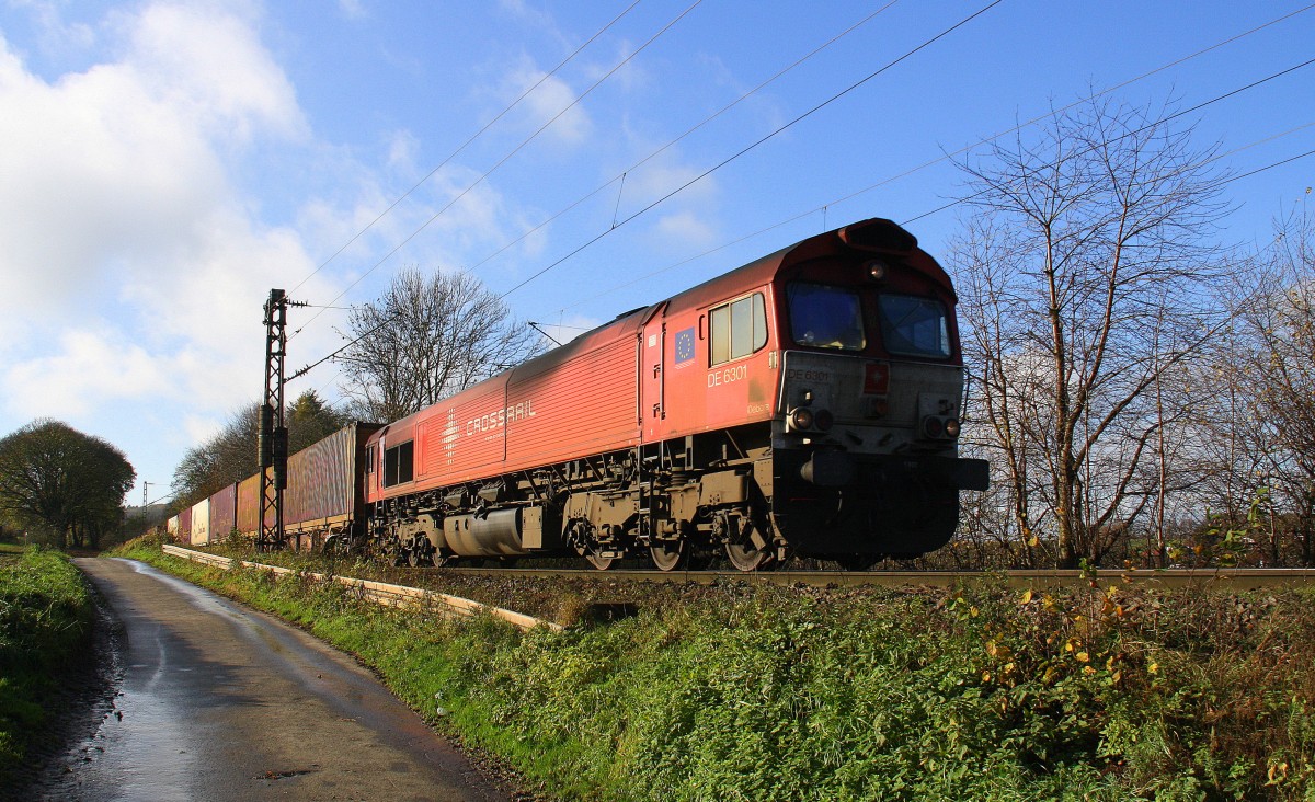 Die Class 66 DE6301  Debora  von Crossrail kommt die Gemmenicher-Rampe herunter nach Aachen-West mit einem langen Containerzug aus Zeebrugge-Ramskapelle(B) nach Milano(I). Aufgenommen an der Montzenroute am Gemmenicher-Weg. 
Bei schönem Novemberwetter am  21.11.2015.