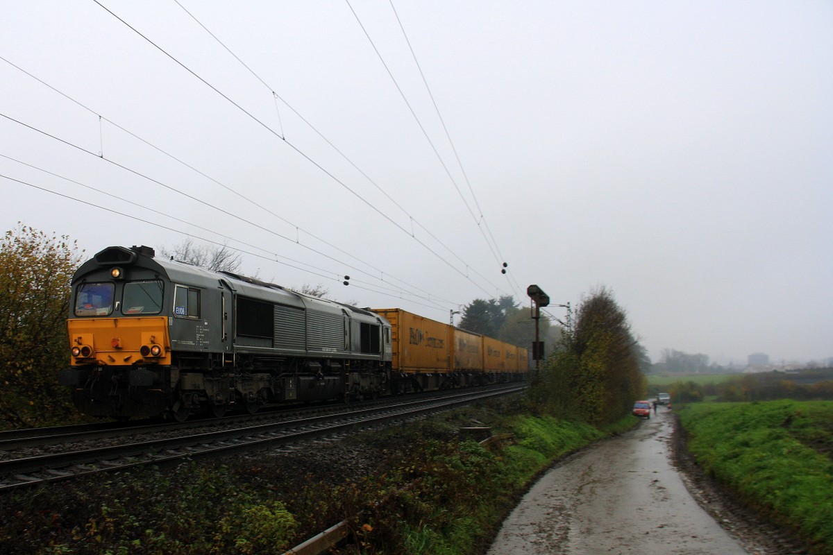 Die Class 66 DE6306 von DLC Railways kommt die Gemmenicher-Rampe hochgefahren mit einem P&O Containerzug aus Gallarate(I) nach Zeebrugge(B) aus Richtung Aachen-West und fhrt in Richtung Montzen(B). 
Aufgenommen an der Montzenroute am Gemmenicher-Weg bei Nieselregen am Nachtmittag vom 24.11.2013.