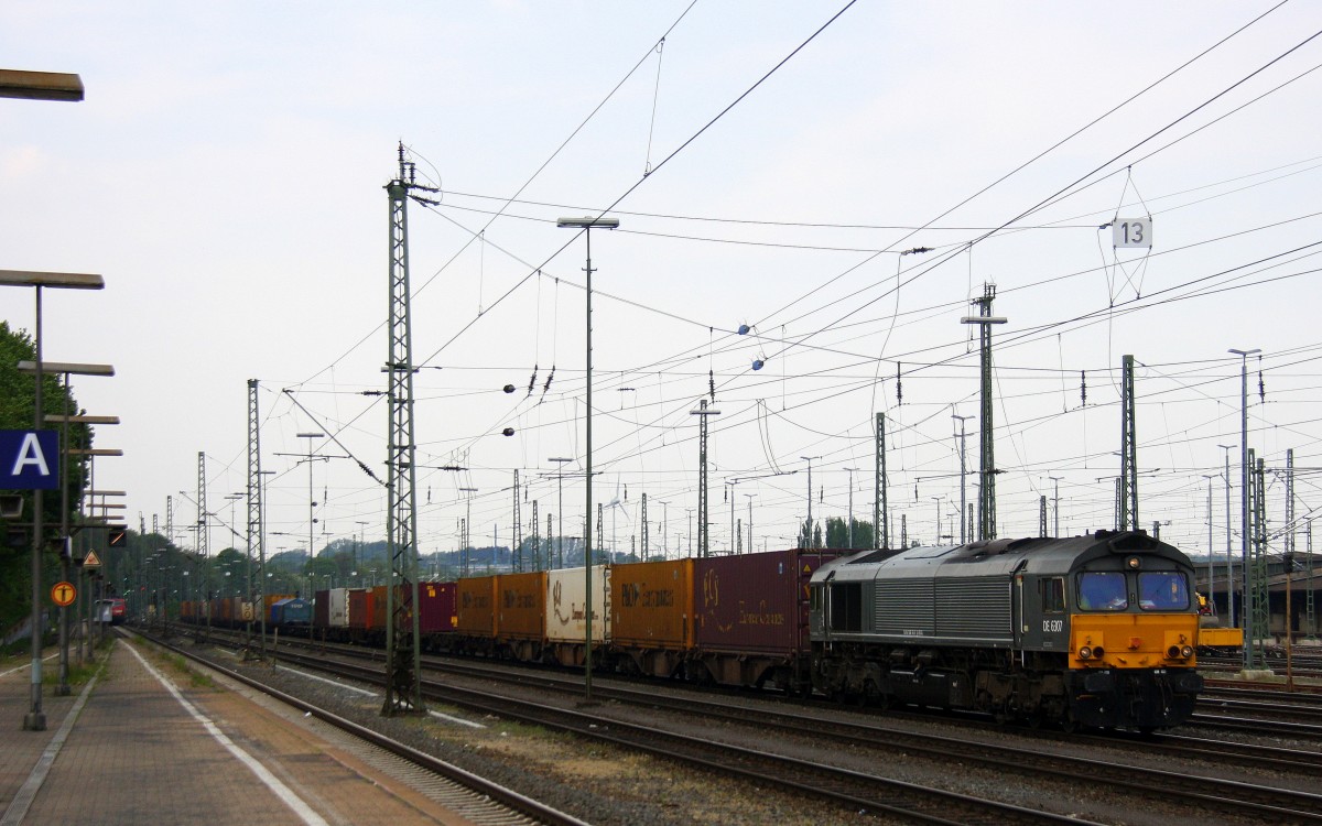 Die Class 66 DE6307 von DLC Railways fährt mit viel Dieselpower mit einem langen Containerzug aus Segrate(I) nach Zeebrugge-Ramskapelle(B) bei der Ausfahrt von Aachen-West und fährt in Richtung Montzen/Belgien bei Sonne und Gewitterwolken am Nachmittag vom 25.4.2014.