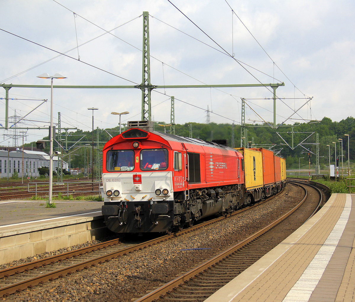 Die Class 66 DE6310  Griet  von Crossrail kommt als Umleiter mit einem MSC-Containerzug aus Germersheim(D) nach Antwerpen-Krommenhoek(B) und kommt aus Richtung Rheydt,Wickrath,Beckrath,Herrath,Erkelenz,Baal,Hückelhoven-Baal,Brachelen,Lindern,Süggerath,Geilenkirchen,Frelenberg,Übach-Palenberg,Rimburg,Finkenrath,Hofstadt und fährt durch Herzogenrath und fährt gleich die Kohlscheider-Rampe hoch in Richtung Kohlscheid,Richterich,Laurensberg,Aachen-West. Aufgenommen am Bahnhof von Herzogenrath. 
Bei schöenem Sonnenschein und Wolken am Vormittag vom 1.5.2018.