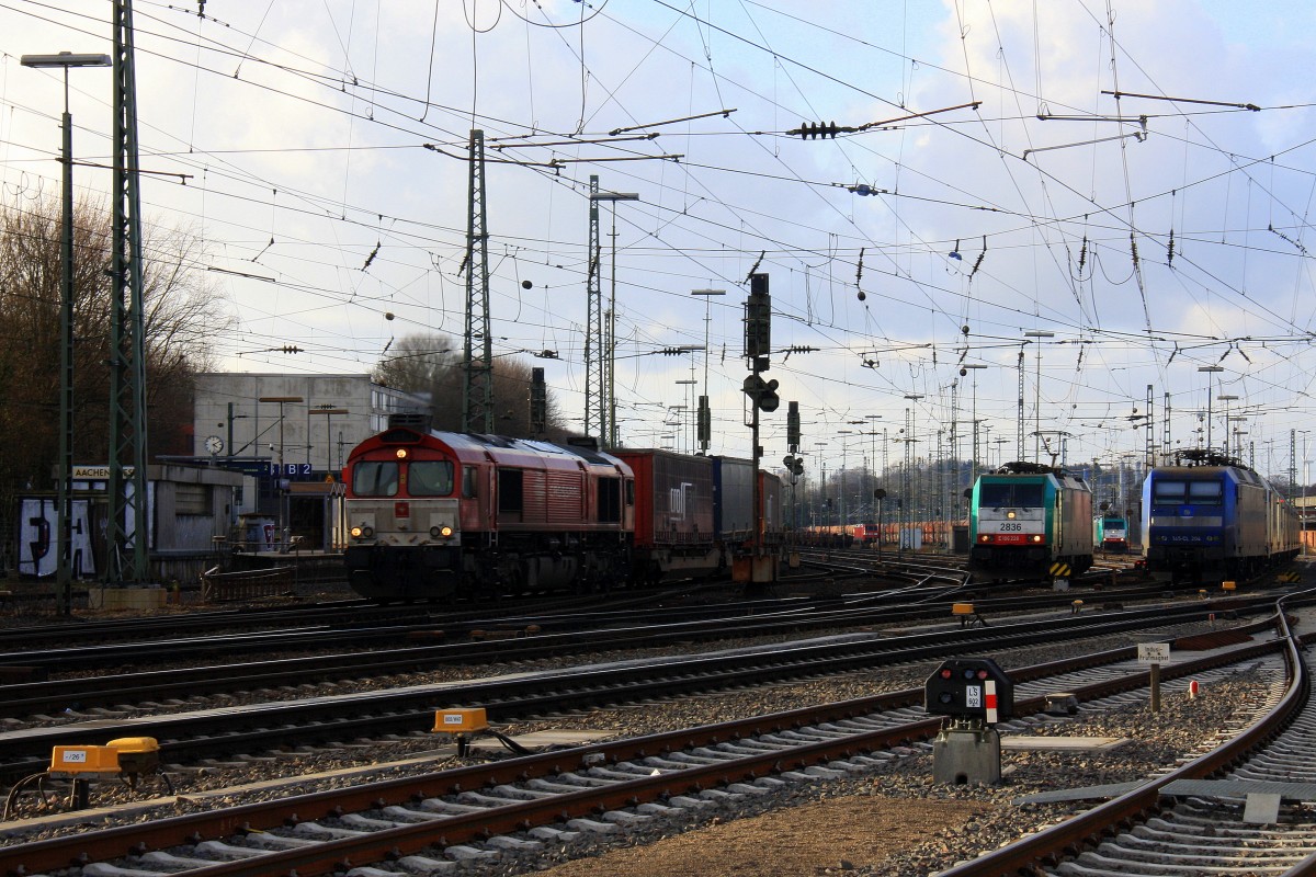 Die Class 66 DE6312  Alix  von Crossrail fährt mit einem langen Containerzug aus Segrate(I) nach Zeebrugge-Ramskapelle(B) bei der Ausfahrt von Aachen-West und fährt in Richtung Montzen/Belgien und im Hintergrund steht die 145 CL-204 von Crossrail mit 8 E-Loks von Crossrail stehen auf dem abstellgleis in Aachen-West und die Cobra 2836 rangiert in Aachen-West bei Sonne und Regenwolken am Nachmittag vom 16.2.2014.