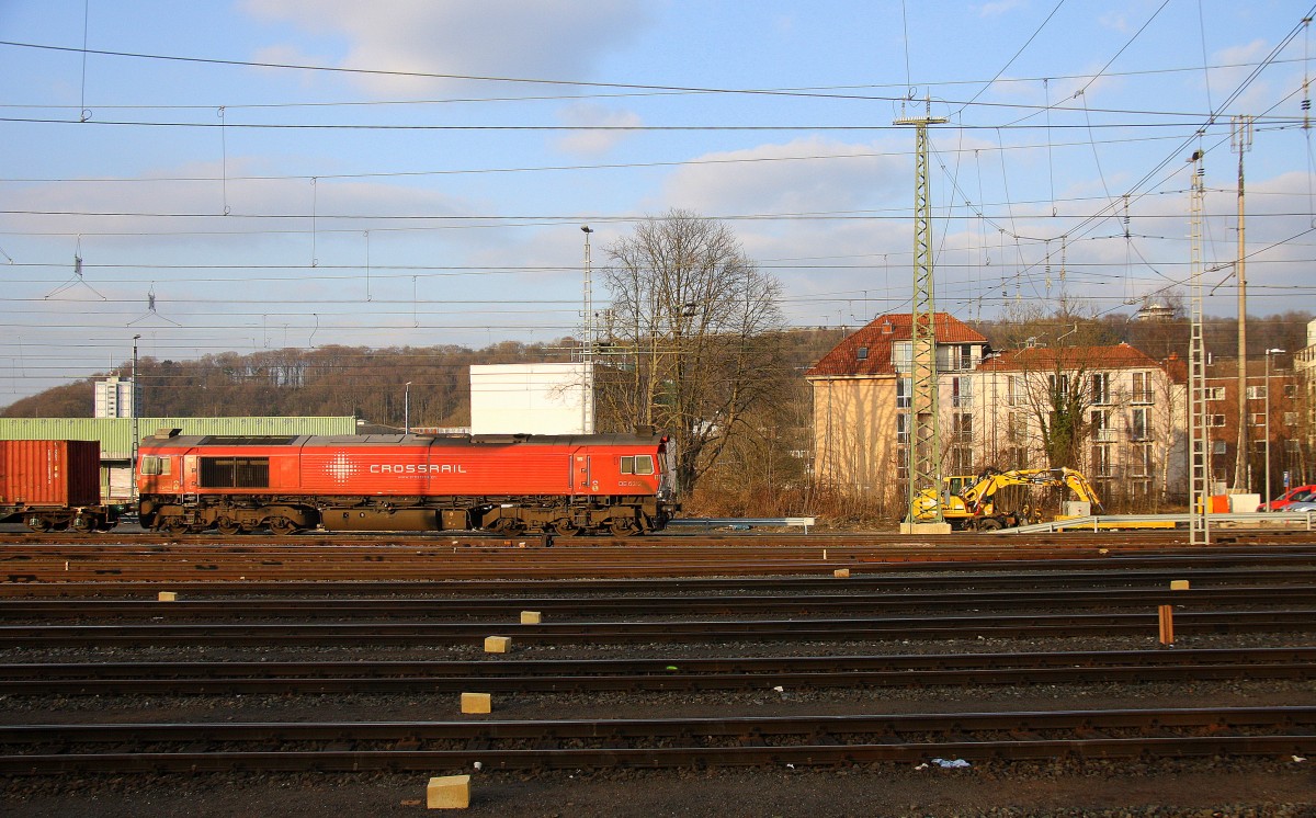 Die Class 66 DE6312  Alix  von Crossrail  fährt mit viel Qualm mit einem langen Containerzug aus Milano(I) nach Zeebrugge-Ramskapelle(B) bei der Ausfahrt aus Aachen-West und fährt in Richtung Montzen/Belgien. Aufgenommen vom Bahnsteig in Aachen-West bei schönem Sonnenschien am Abend vom 13.3.2015.