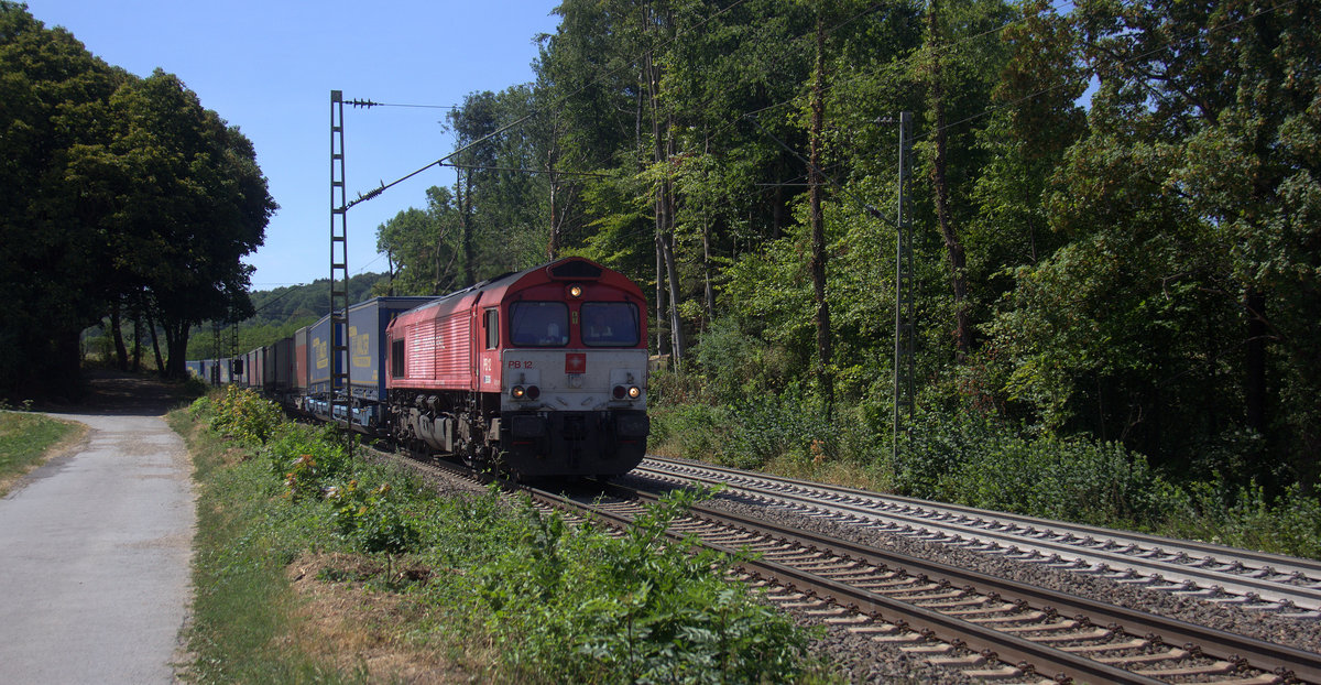 Die Class 66 PB12   Marleen  von Crossrail kommt die Gemmenicher-Rampe herunter nach Aachen-West mit einem LKW-Zug aus Zeebrugge(B) nach Novara(I). 
Aufgenommen an der Montzenroute am Gemmenicher-Weg. 
Bei Sommerwetter am Nachmittag vom 5.8.2018.