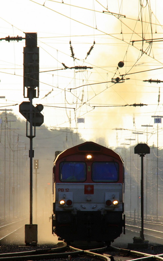 Die Class 66 PB12  Marleen  von Crossrail fhrt mit viel Qualm und Sand mit einem langen Ewals-Cargo-Care Containerzug aus Novara(I) nach Genk-Zuid-Haven(B) bei der Ausfahrt aus Aachen-West und fhrt in Richtung Montzen/Belgien in der schnen Abendstimmung am 9.7.2013.