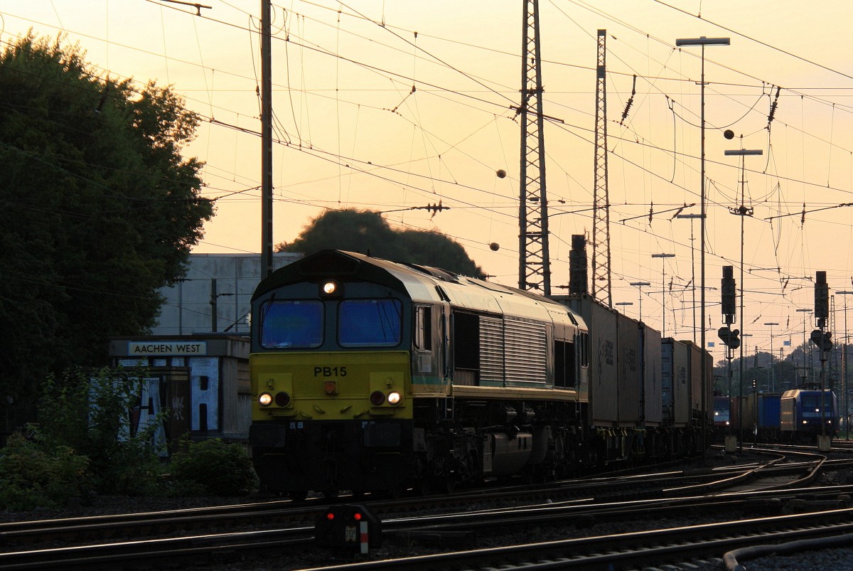 Die Class 66 PB15 von Railtraxx BVBA fhrt mit viel Gas mit einem langen Ewals-Cargo-Care Containerzug aus Novara(I) nach Genk-Zuid-Haven(B) bei der Ausfahrt aus Aachen-West und fhrt in Richtung Montzen/Belgien in der schnen Abendstimmung am 23.8.2013. 