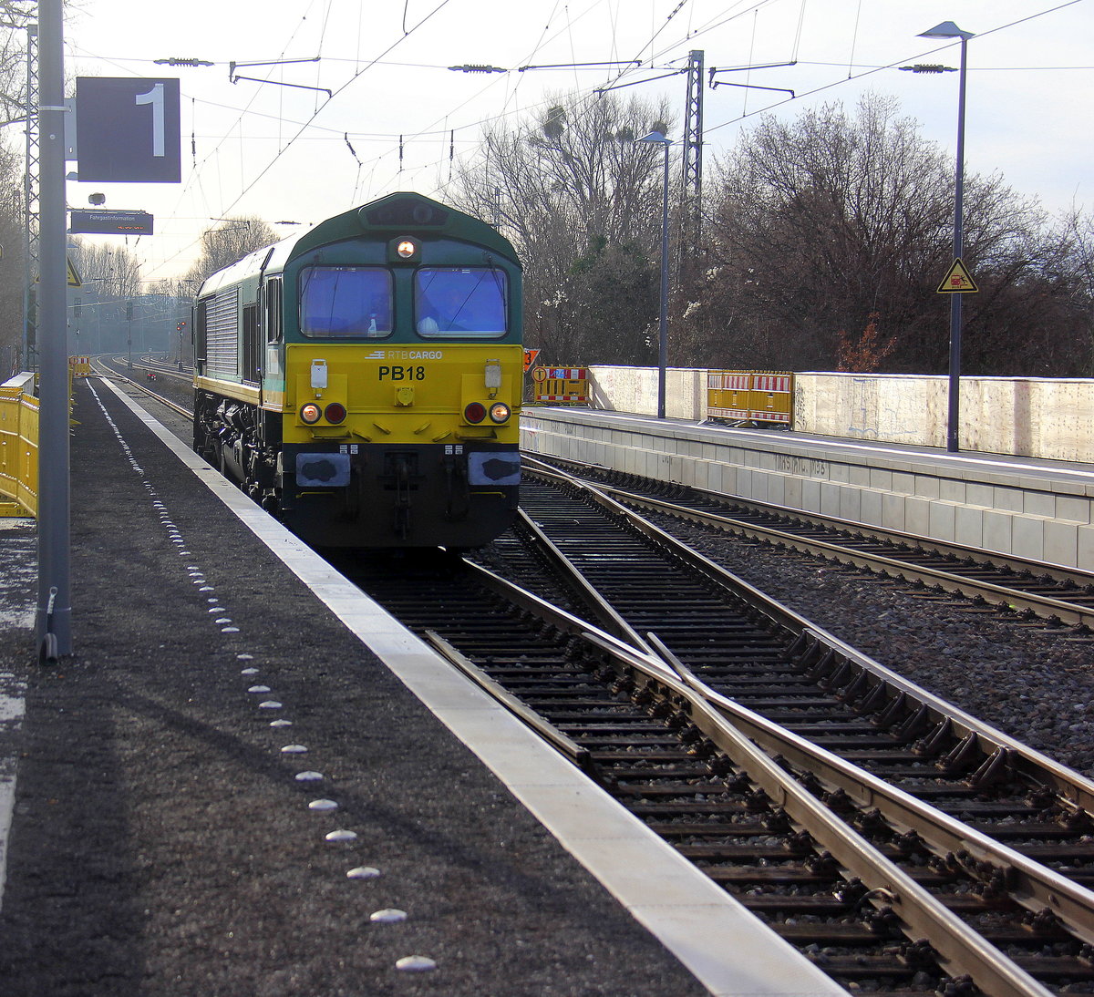 Die Class 66 PB18 von der Rurtalbahn-Cargo kommt aus Richtung Aachen-West,Laurensberg,Richterich und fährt durch Kohlscheid und fährt als Lokzug aus Aachen-West nach Oberhausen-West in Richtung Herzogenrath,Hofstadt,Finkenrath,Rimburg,Übach-Palenberg,Zweibrüggen,Frelenberg,Geilenkirchen,Süggerath,Lindern,Brachelen,Hückelhoven-Baal,Baal,Erkelenz,Herrath,Beckrath,Wickrath. 
Aufgenommen von Bahnsteig 1 in Kohlscheid. 
Bei schönem Winterwetter am kalten Mittag vom 27.12.2018.