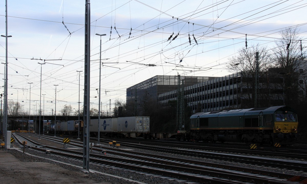 Die Class 66 PB20 von Railtraxx BVBA kommt aus Richtung Montzen/Belgien mit einem langen Containerzug aus Zeebrugge-Ramskapelle(B) nach Duisburg-Rheinhausen(D) und fährt in Aachen-West ein bei Sonne und Wolken am 18.1.2014.