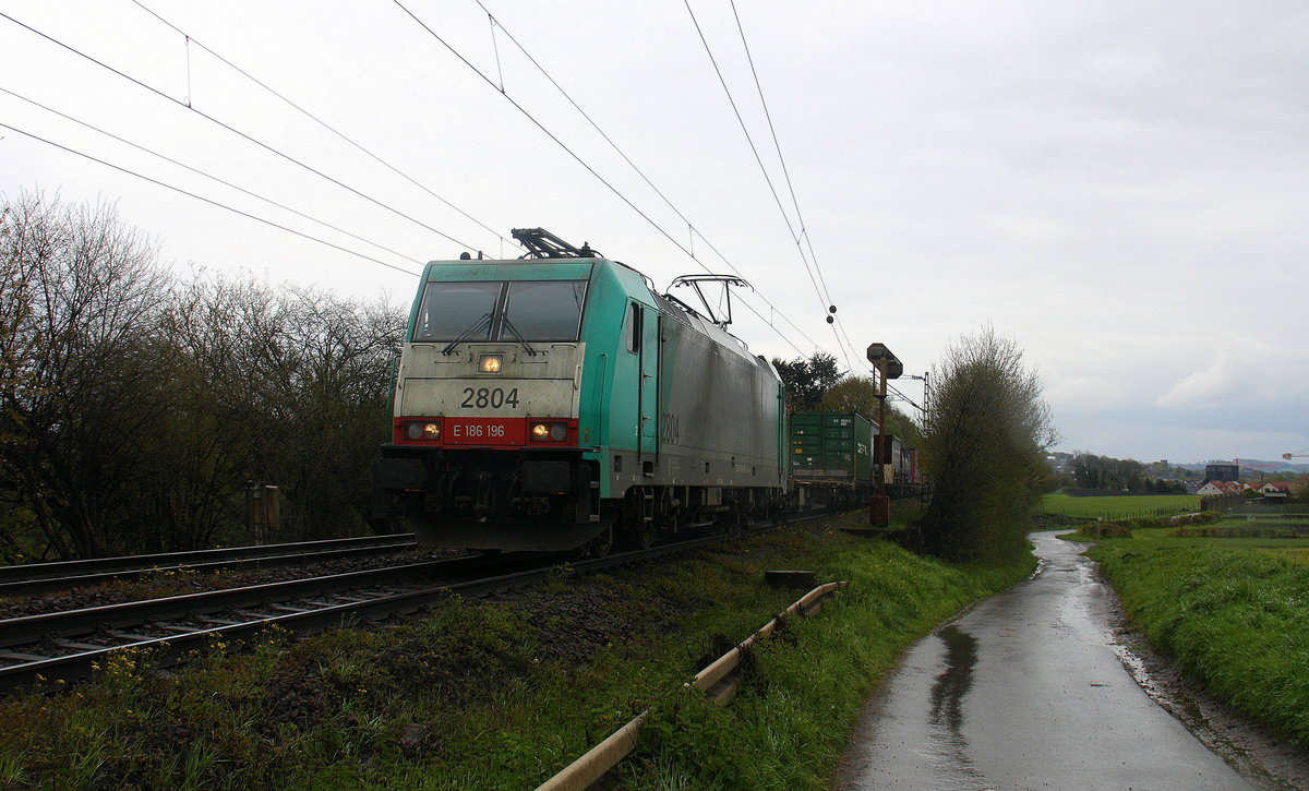 Die Cobra 2804  kommt die Gemmenicher-Rampe auf dem falschen Gleis hochgefahren aus Richtung Aachen-West mit einem langen Containerzug aus Gallarate(I) nach Antwerpen-Oorderen(B) und fährt in Richtung Montzen/Belgien. 
Aufgenommen an der Montzenroute am Gemmenicher-Weg.
Bei Regenwetter am Nachmittag vom 30.4.2016.