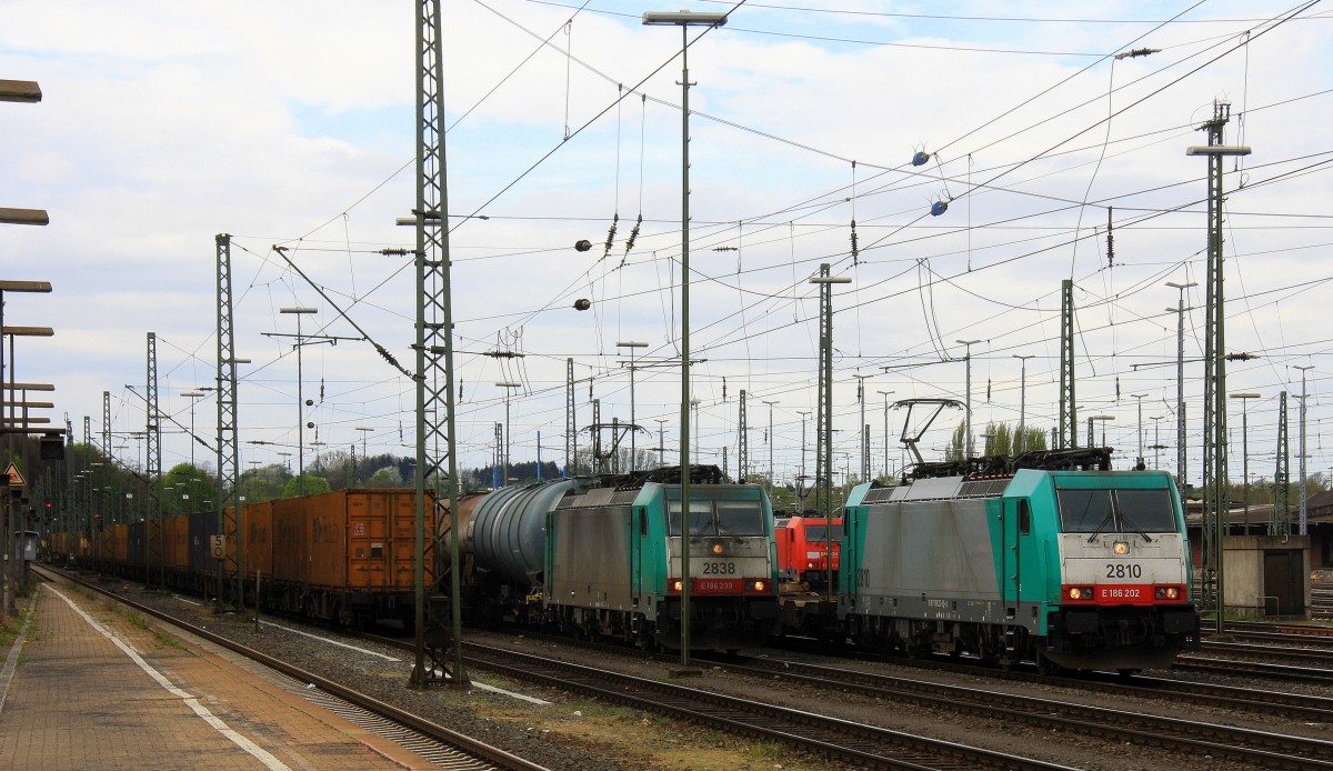 Die Cobra 2810 fährt mit einem langen Containerzug aus Verona(I) nach Antwerpen-Noord(B), aufgenommen bei der Ausfahrt aus Aachen-West in Richtung Montzen/Belgien.
Links daneben Cobra 2838 mit einem langen Kesselzug, im Hintergrund 185 299-5  von Railion mit einem langen Ölzug.
Aufgenommen vom Bahnsteig in Aachen-West bei Sonne und Regenwolken am Nachmittag vom 6.4.2014.