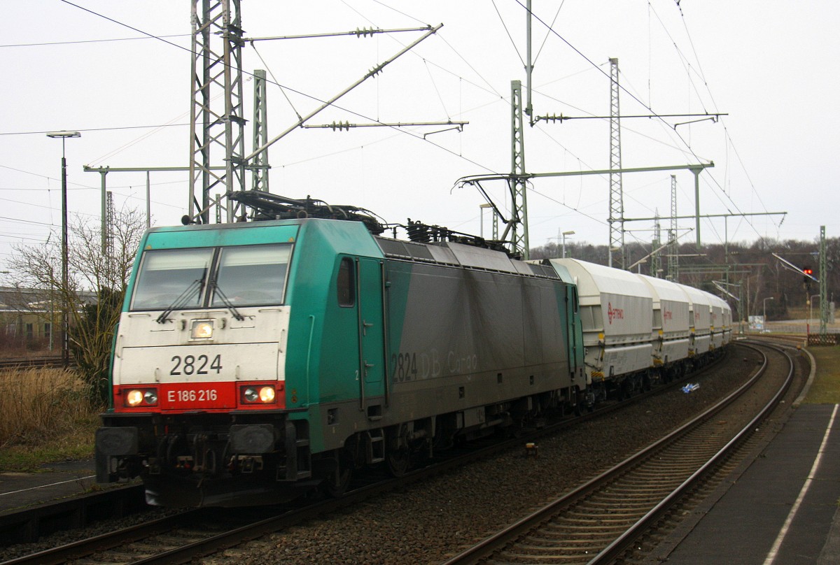 Die Cobra 2824 kommt durch Herzogenrath mit einem Kalkleerzug aus Millingen-Solvay(D) nach Yves-Gomezee(B) und fährt in Richtung Kohlscheid,Richterich,Laurensberg,Aachen-West. Aufgenommen am Bahnhof von Herzogenrath. Bei Sonne und Schneeschauer am Kalten Nachmittag vom 25.2.2016.