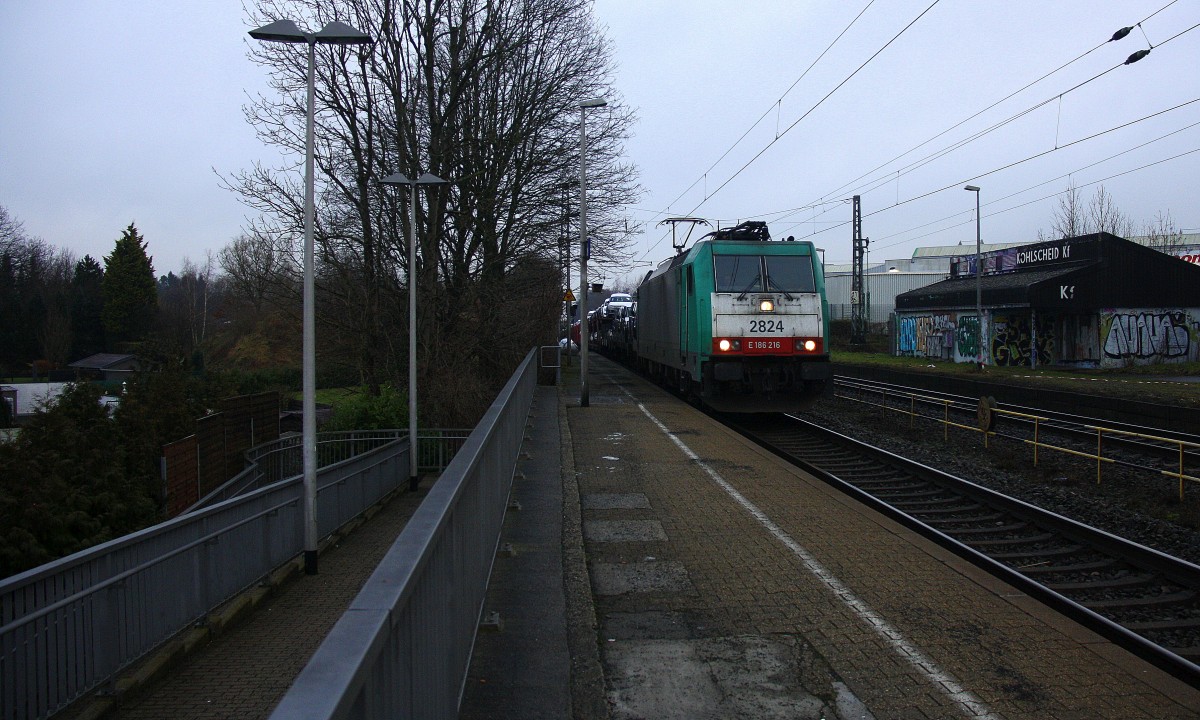 Die Cobra 2824 kommt die Kohlscheider-Rampe hoch  aus Richtung Neuss,Herzogenrath mit einem langen VW-Autozug aus Osnabrück nach Kortenberg-Goederen(B) und fährt durch Kohlscheid  und fährt in Richtung Richterich,Laurensberg,Aachen-West. 
Bei Wolken am Kalten Morgen vom 27.1.2015.