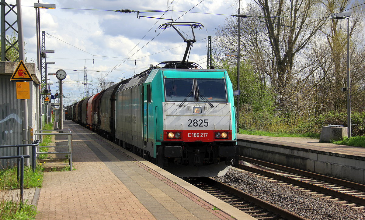 Die Cobra 2825  kommt als Umleiter mit einem gemischten Güterzug aus Köln-Gremberg(D) nach Antwerpen-Nord(B) und kommt aus Richtung Köln-Gremberg,Köln-Poll,Kölner-Südbrücke,Köln-Süd,Köln-West,Köln-Nippes,Köln-Longerich,Köln-Chorweiler,Köln-Worringen,Dormagen-Bayerwerk,Dormagen und fährt durch Nievenheim in Richtung Neuss-Allerheiligen,Norf,Neuss-Süd,Neuss-Hbf,Meerbusch-Osterath,Krefeld-Oppum,,Krefeld-Hbf,Forsthaus,Anrath,Viersen,Mönchengladbach,Rheydt-Gbf,Wickrath,Herrath,Erkelenz,Hückelhoven-Baal,Brachelen,Lindern,Süggerath,Geilenkirchen,Frelenberg,Zweibrüggen,Übach-Palenberg,Rimburg,Finkenrath,Hofstadt,Herzogenrath, Kohlscheid,Richterich,Laurensberg,Aachen-West. 
Aufgenommen vom Bahnsteig 1 in Nievenheim. 
Bei Sonne und Wolken am Nachmittag vom 15.4.2018.