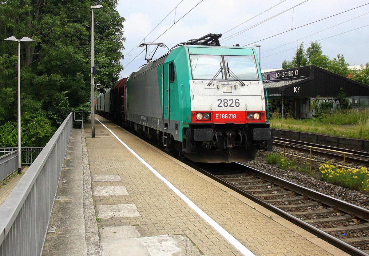 Die Cobra 2826 kommt als Umleiter mit einem langen gemischten Güterzug aus Köln-Gremberg(D) nach Antwerpen-Noord(B) nd fährt durch Kohlscheid aus Richtung Herzogenrath und fährt die Kohlscheider-Rampe hoch nach Aachen-West. Bei Sonne und Regenwolken am 27.6.2015.